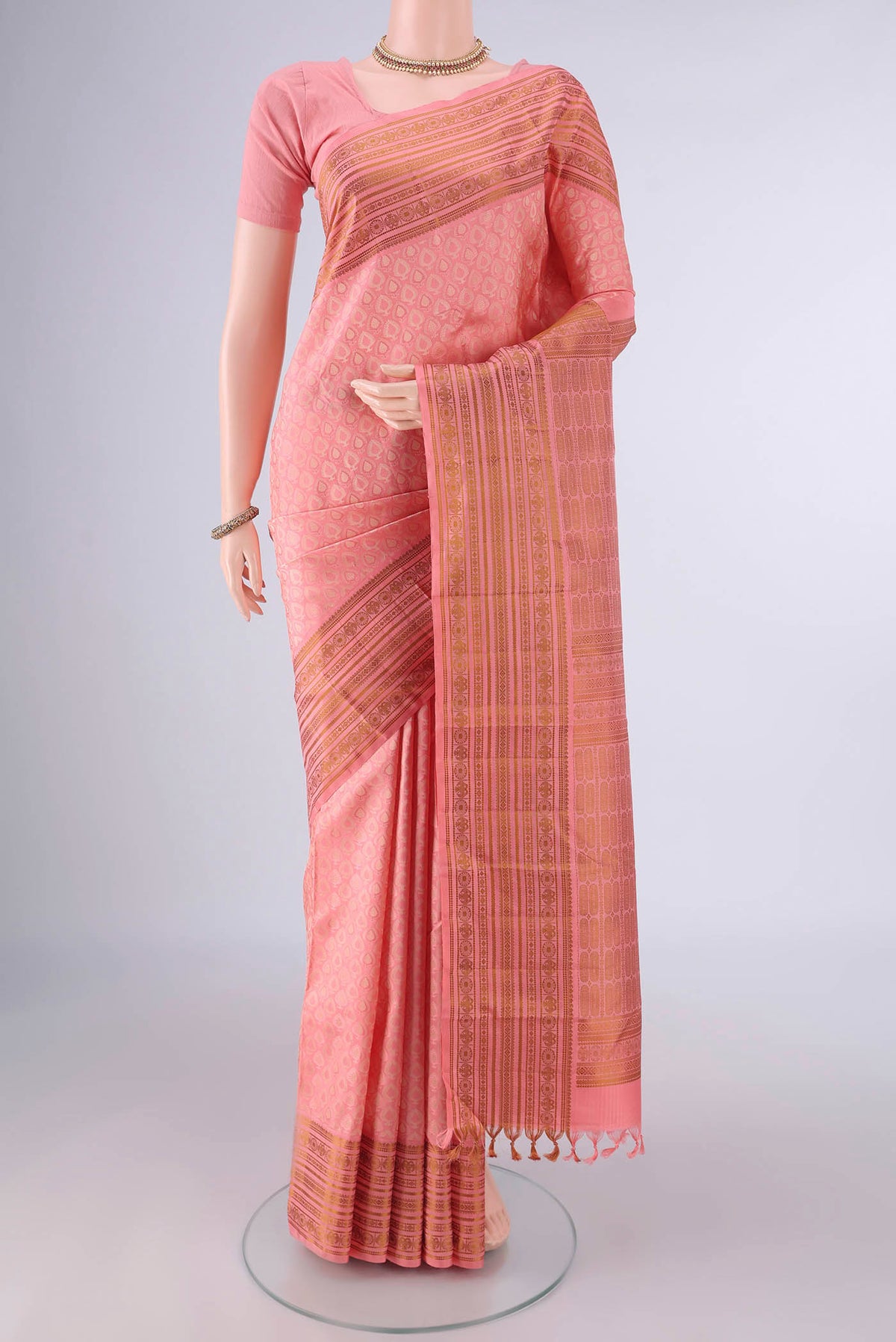 Pure Silk Peach Kanjivaram Saree with Jacquard design on the body and Thread Border.  displayed on a mannequin