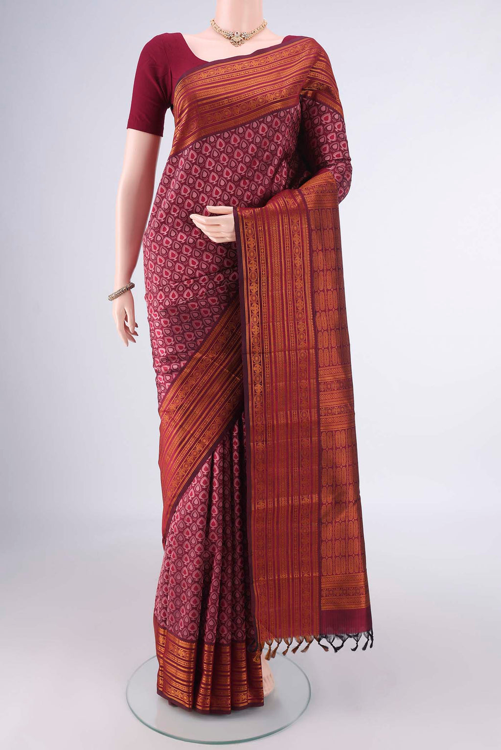 Pure Silk Maroon Kanjivaram Saree with Jacquard design on the body and Thread Border.  displayed on a mannequin