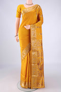Mustard Baluchari Silk Saree with Zari And Thread Butta on the body and Zari And Thread Border.  displayed on a mannequin