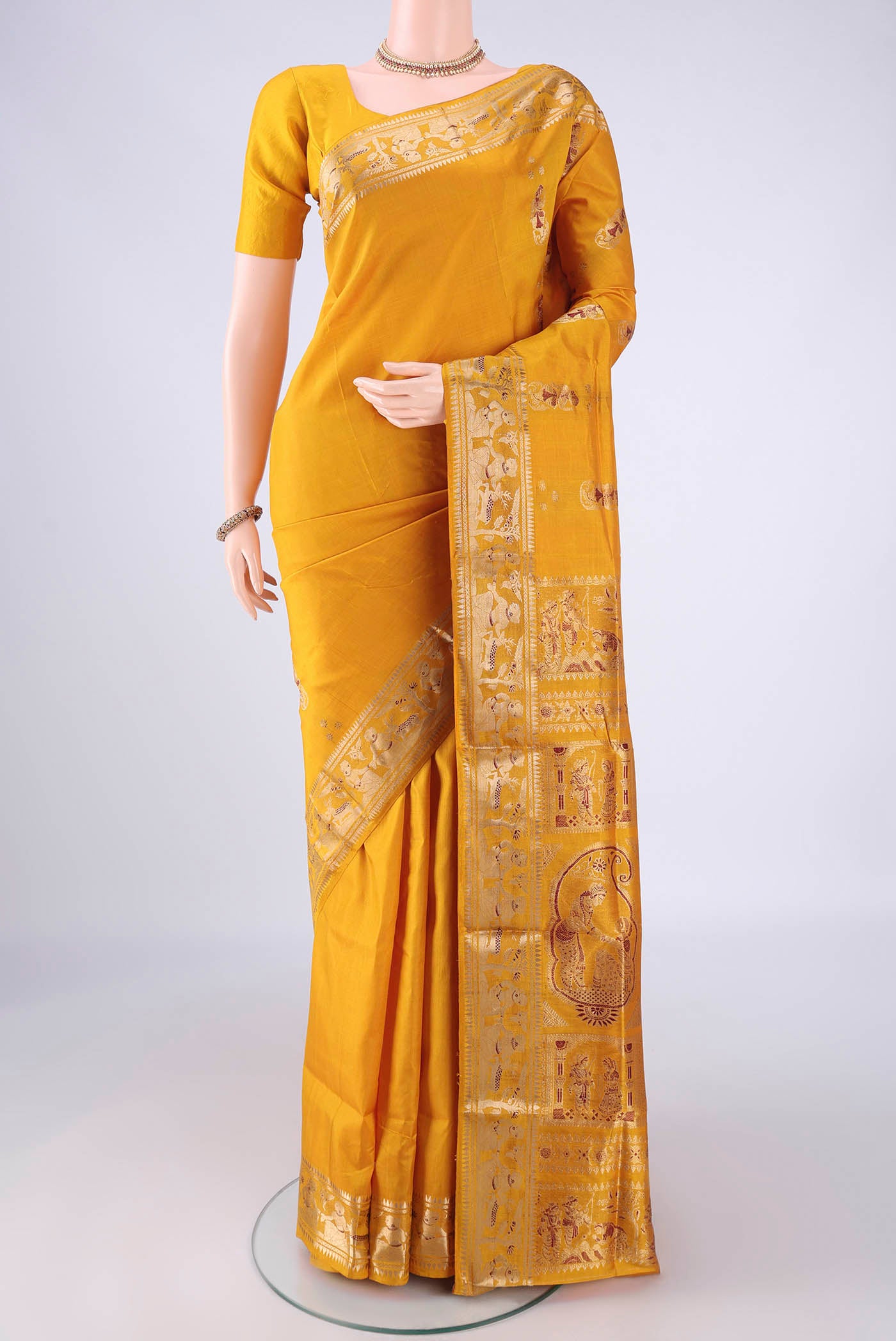 Mustard Baluchari Silk Saree with Zari And Thread Butta on the body and Zari And Thread Border.  displayed on a mannequin