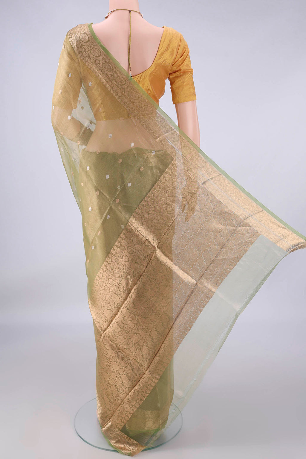 Flat view of Pista Green Organza Saree with Zari Butta on the body and Zari Border. 