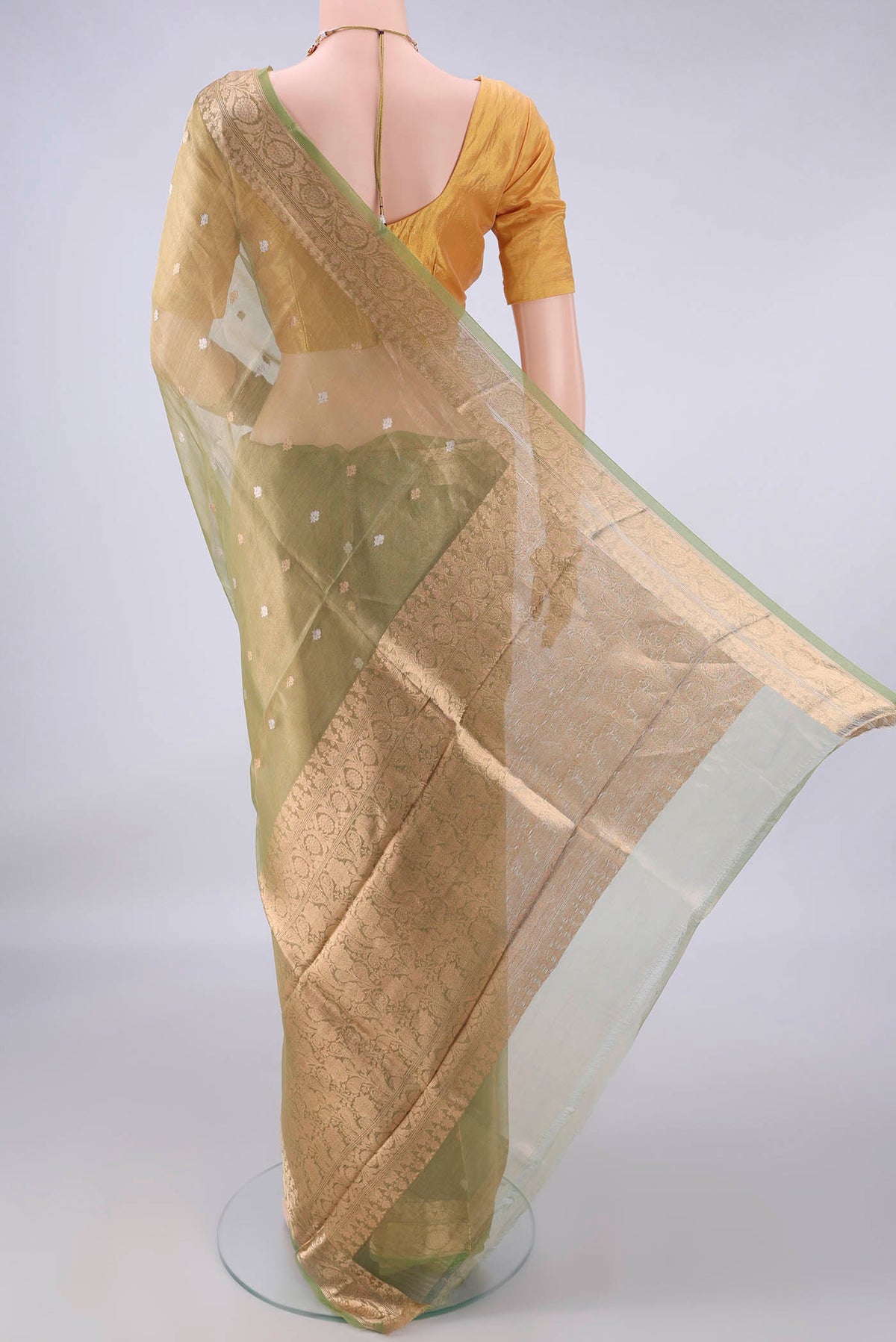 Flat view of Pista Green Organza Saree with Zari Butta on the body and Zari Border. 