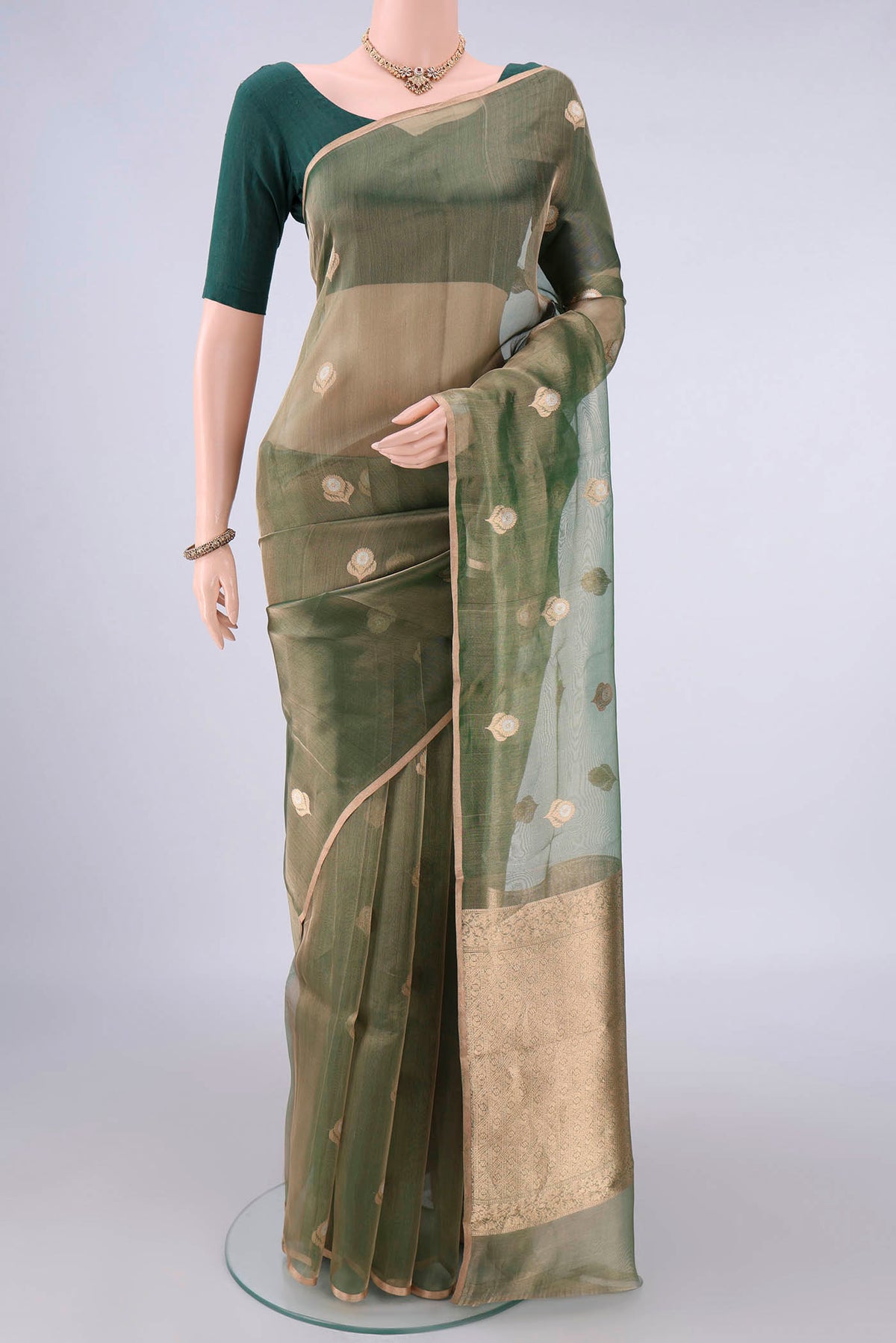 Green Organza Saree with Zari Butta on the body and Zari Border.  displayed on a mannequin