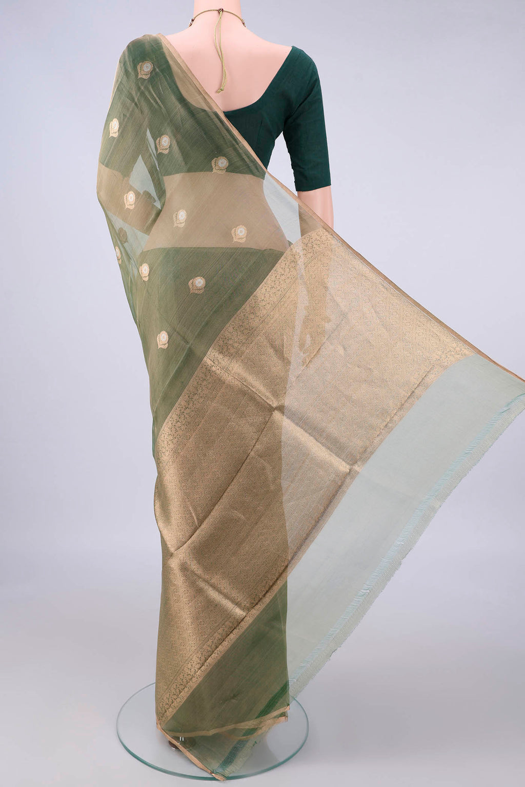 Flat view of Green Organza Saree with Zari Butta on the body and Zari Border. 