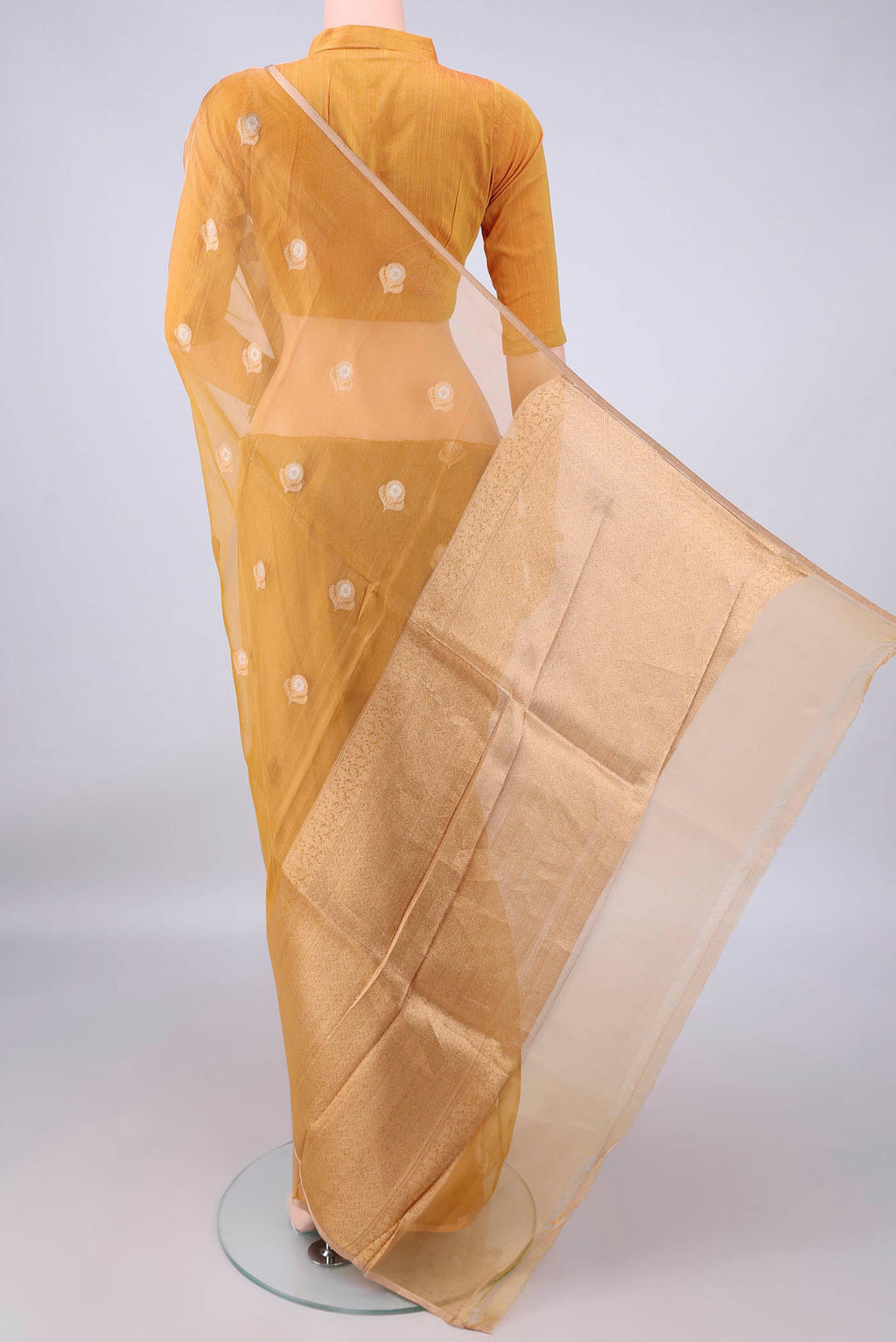 Flat view of Golden Organza Saree with Zari Butta on the body and Thin Zari Line. 