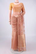 Peach Organza Saree with Zari And Thread Butta on the body and Thin Zari Line.  displayed on a mannequin