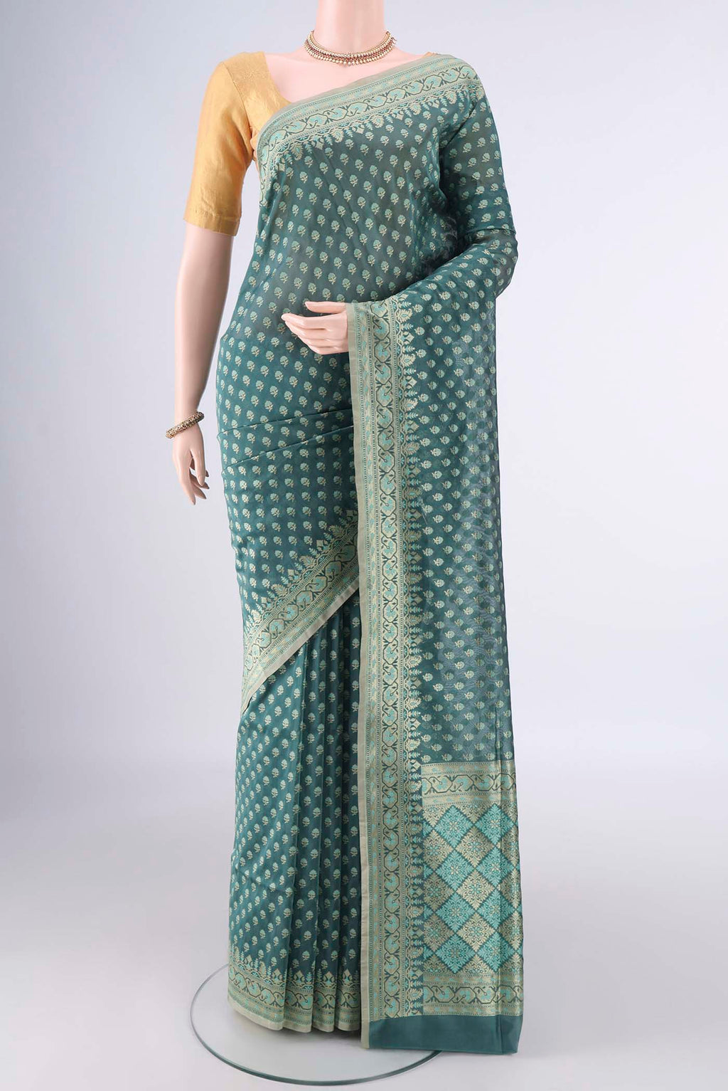 Pure Silk Teal Banarasi Saree with Zari Butta on the body and Zari Border.  displayed on a mannequin