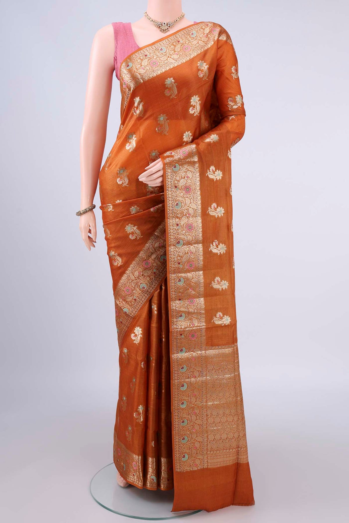 Rust Banarasi Tussar Saree with Zari And Thread Butta on the body and Zari Border.  displayed on a mannequin