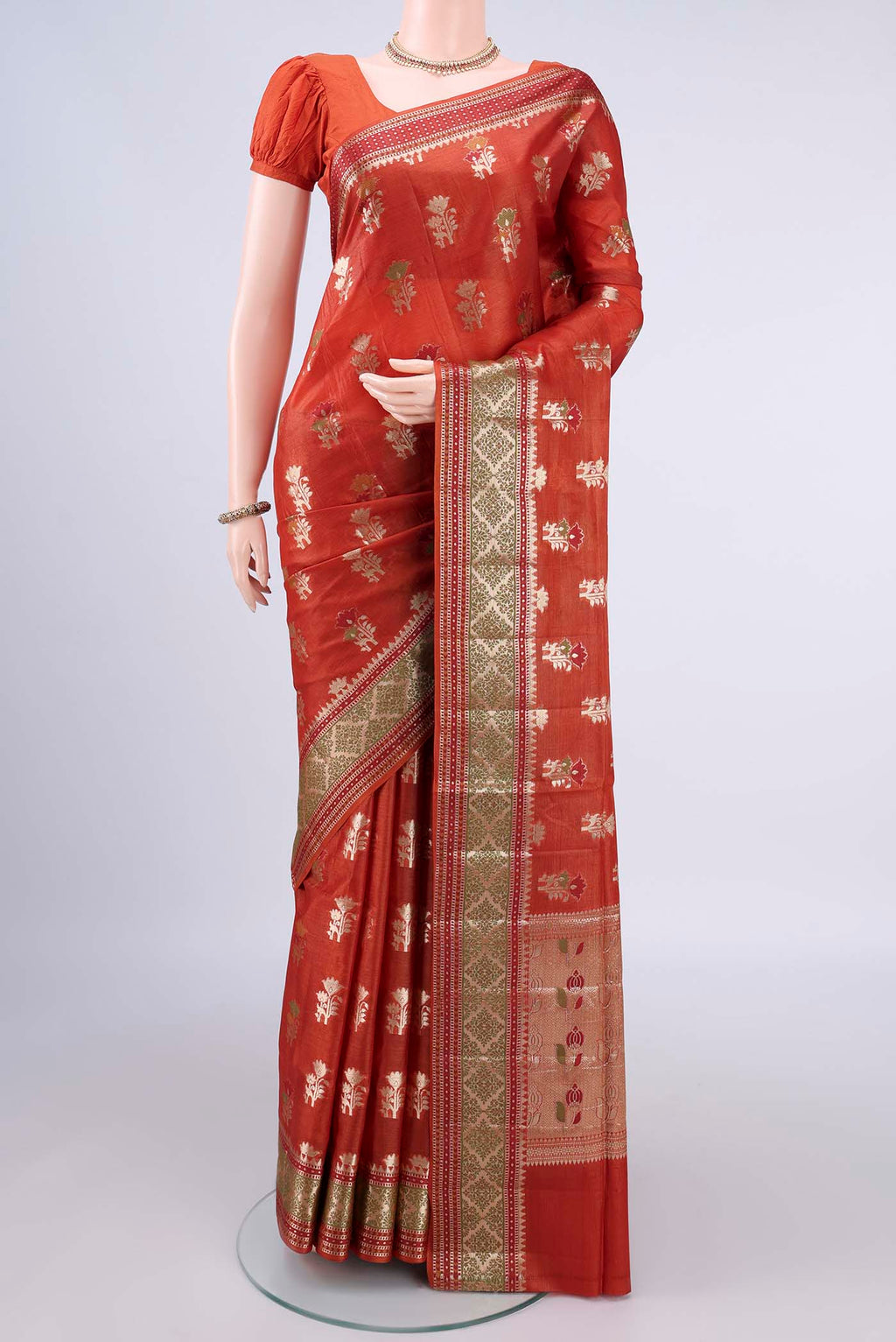 Rust Banarasi Tussar Saree with Zari And Thread Butta on the body and Zari Border.  displayed on a mannequin