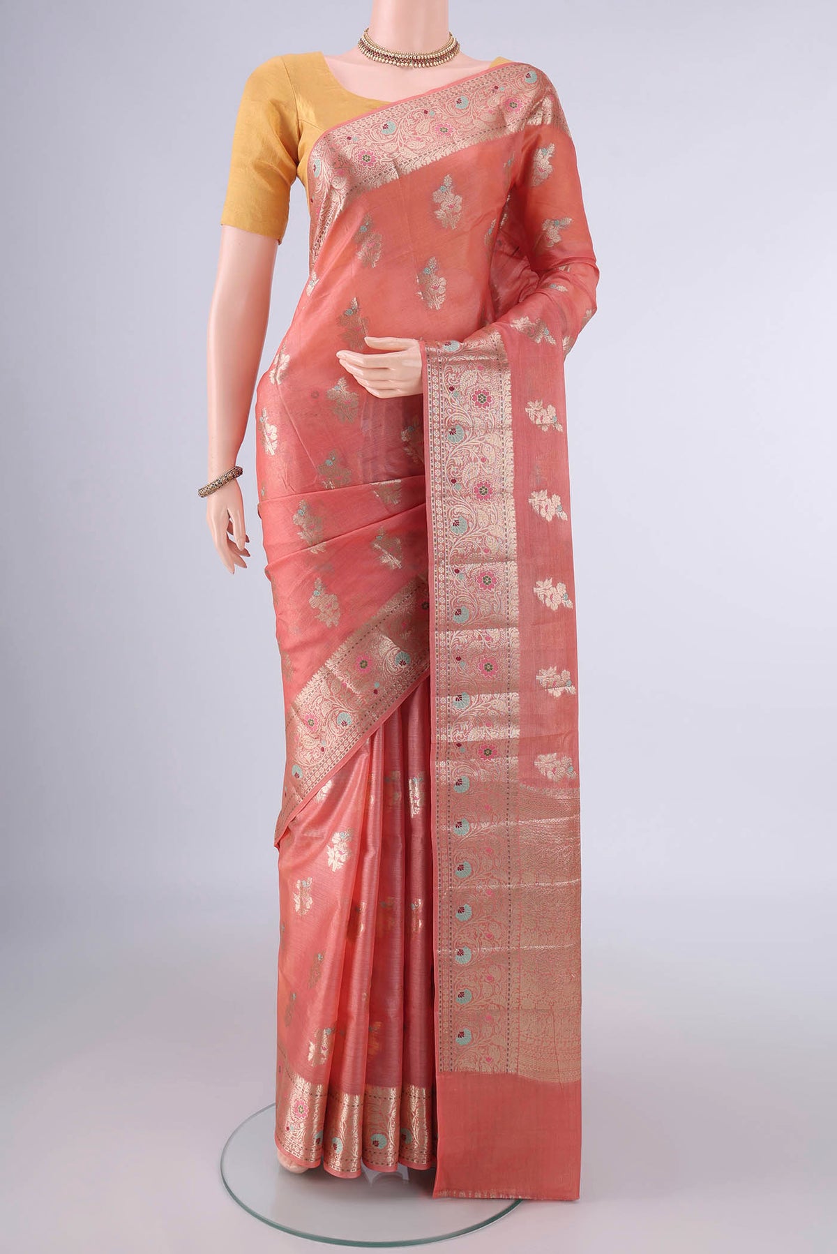 Peach Banarasi Tussar Saree with Zari And Thread Butta on the body and Zari Border.  displayed on a mannequin