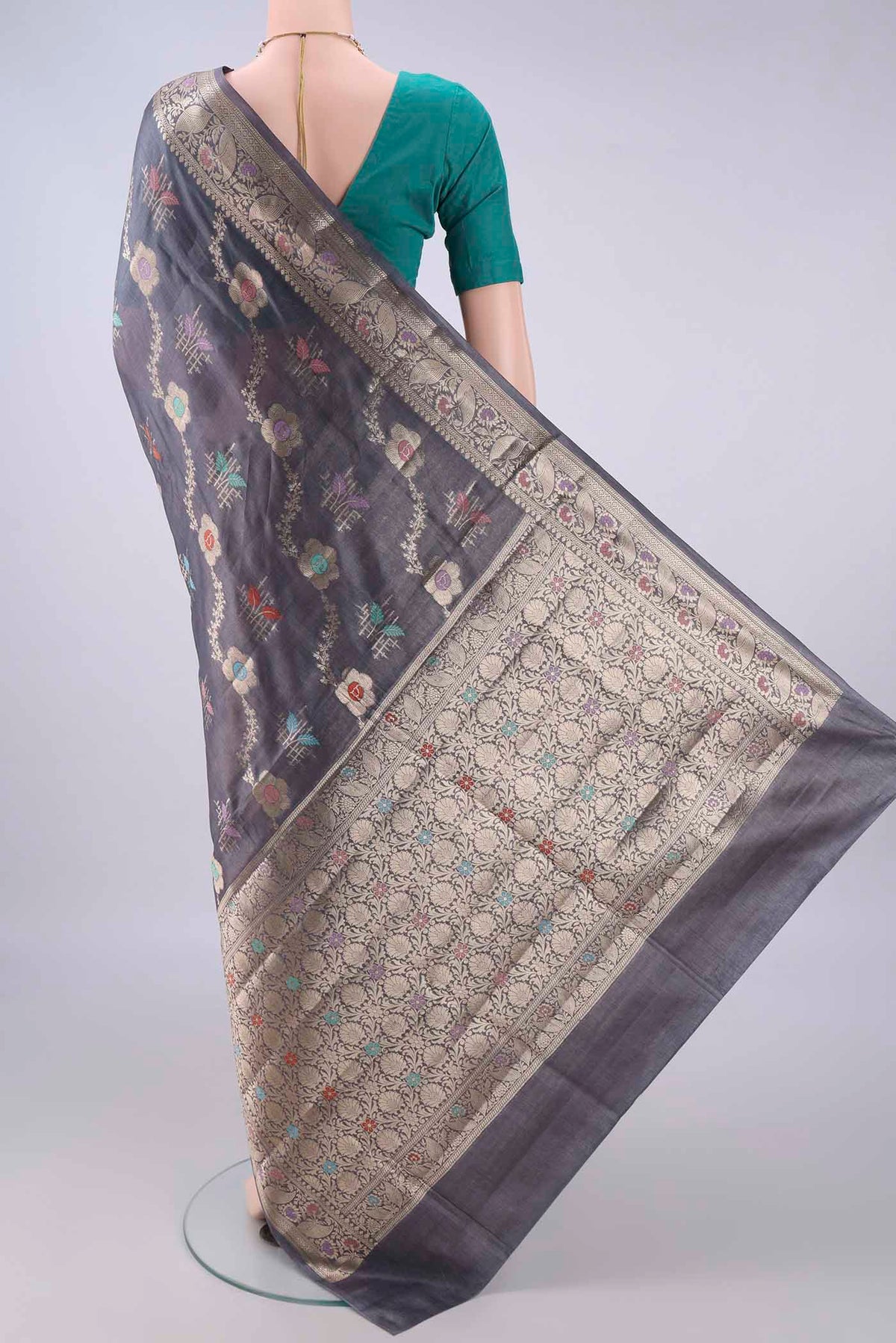 Flat view of Pure Silk Davys Grey Banarasi Tussar Saree with Zari And Thread Butta on the body and Zari And Thread Border. 