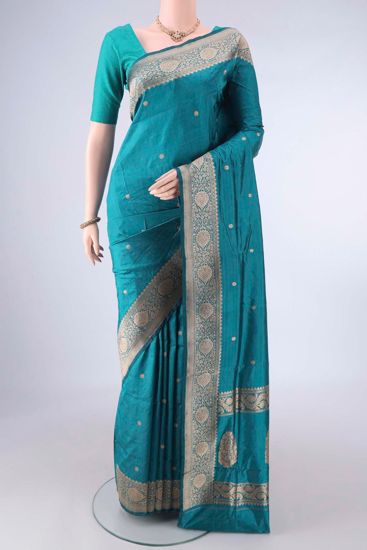 Pure Silk Teal Banarasi Katan Saree with Zari Butta on the body and Zari Border.  displayed on a mannequin