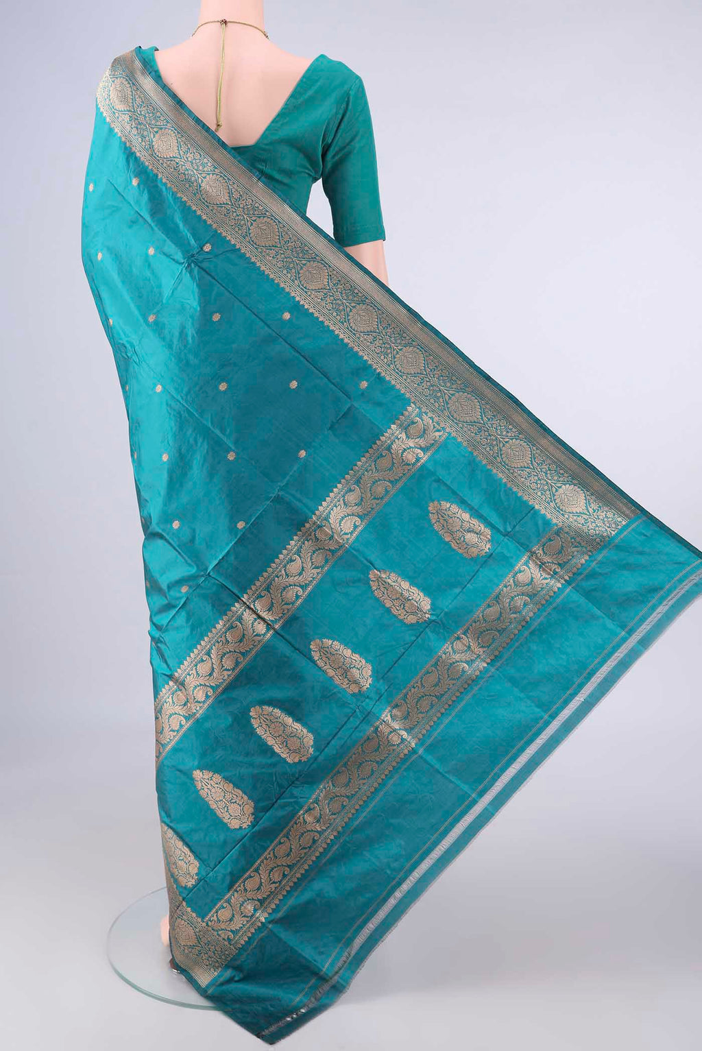Flat view of Pure Silk Teal Banarasi Katan Saree with Zari Butta on the body and Zari Border. 