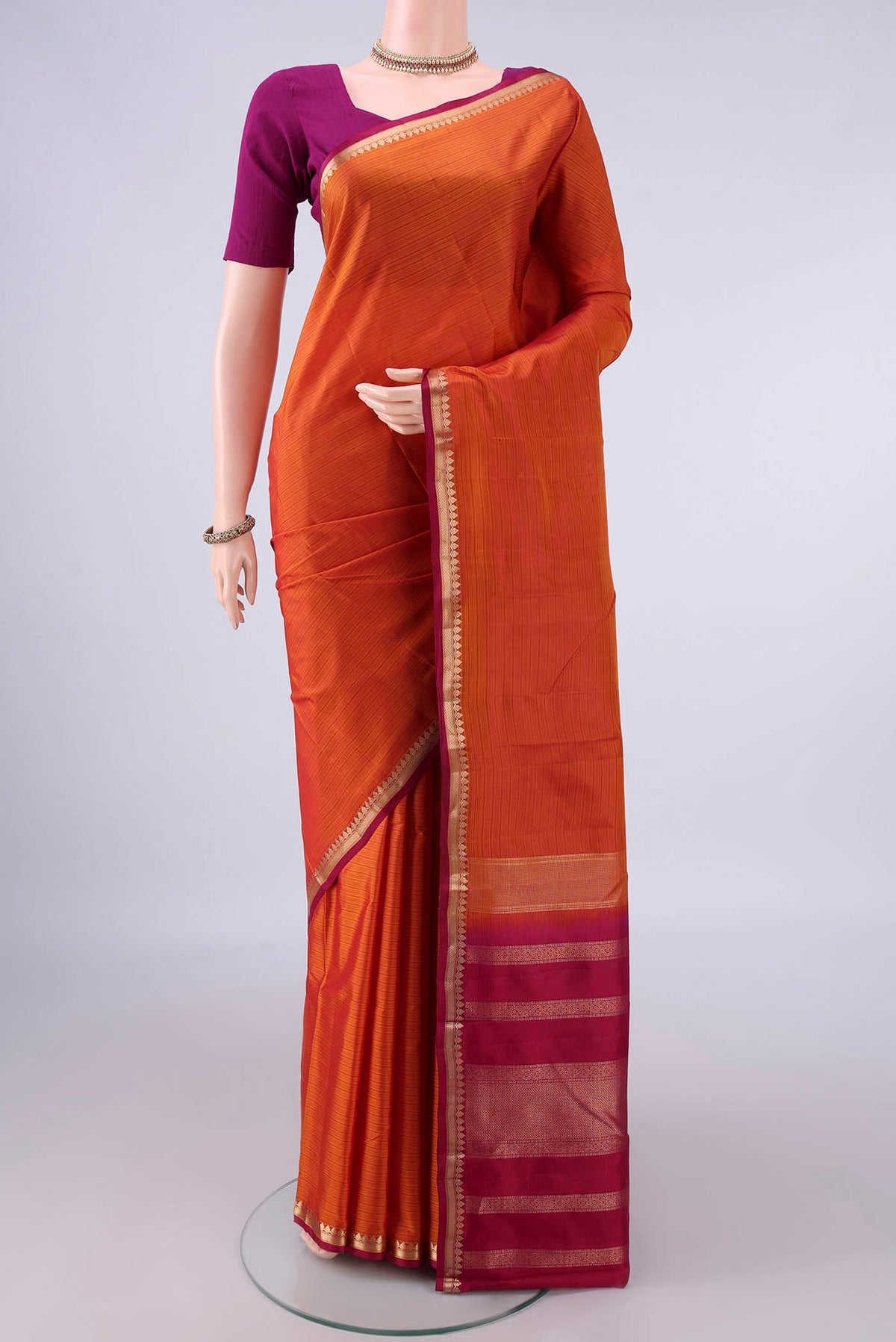 Pure Silk Orange Kanjivaram Saree with Stripes on the body and Zari Border.  displayed on a mannequin