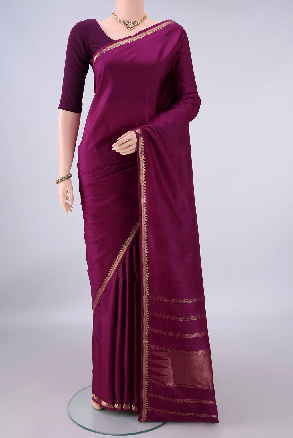 Pure Silk Magenta Kanjivaram Saree with Plain Body and Zari Border.  displayed on a mannequin