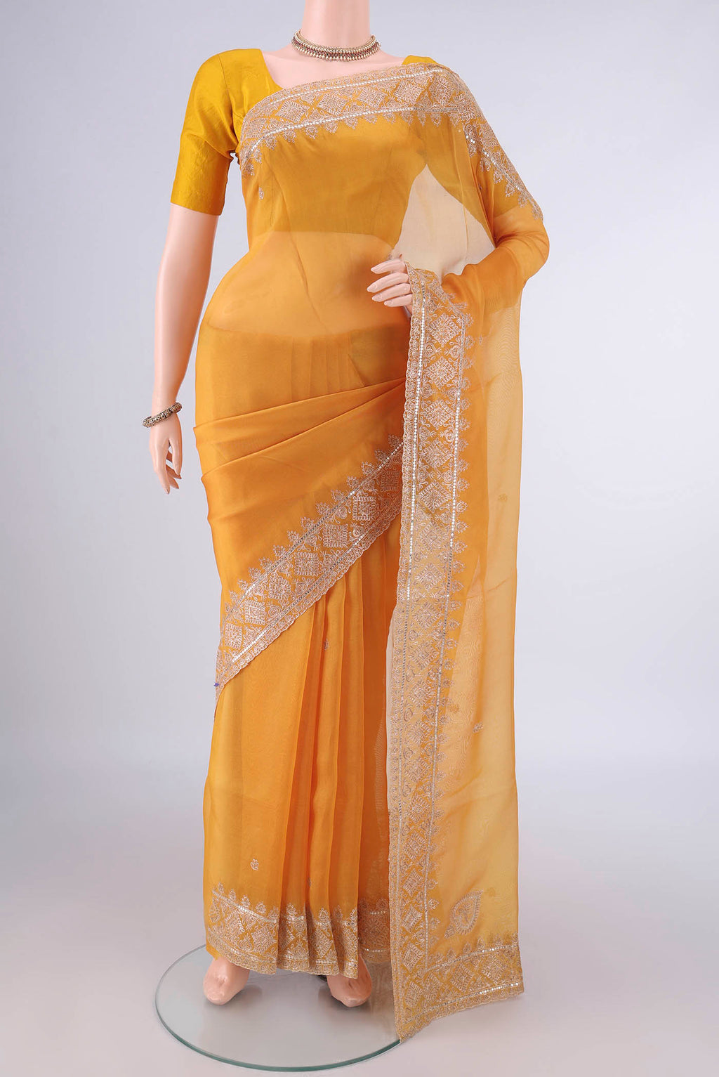 Yellow Organza Saree with Embroidery on the body and Embroidery Border.  displayed on a mannequin