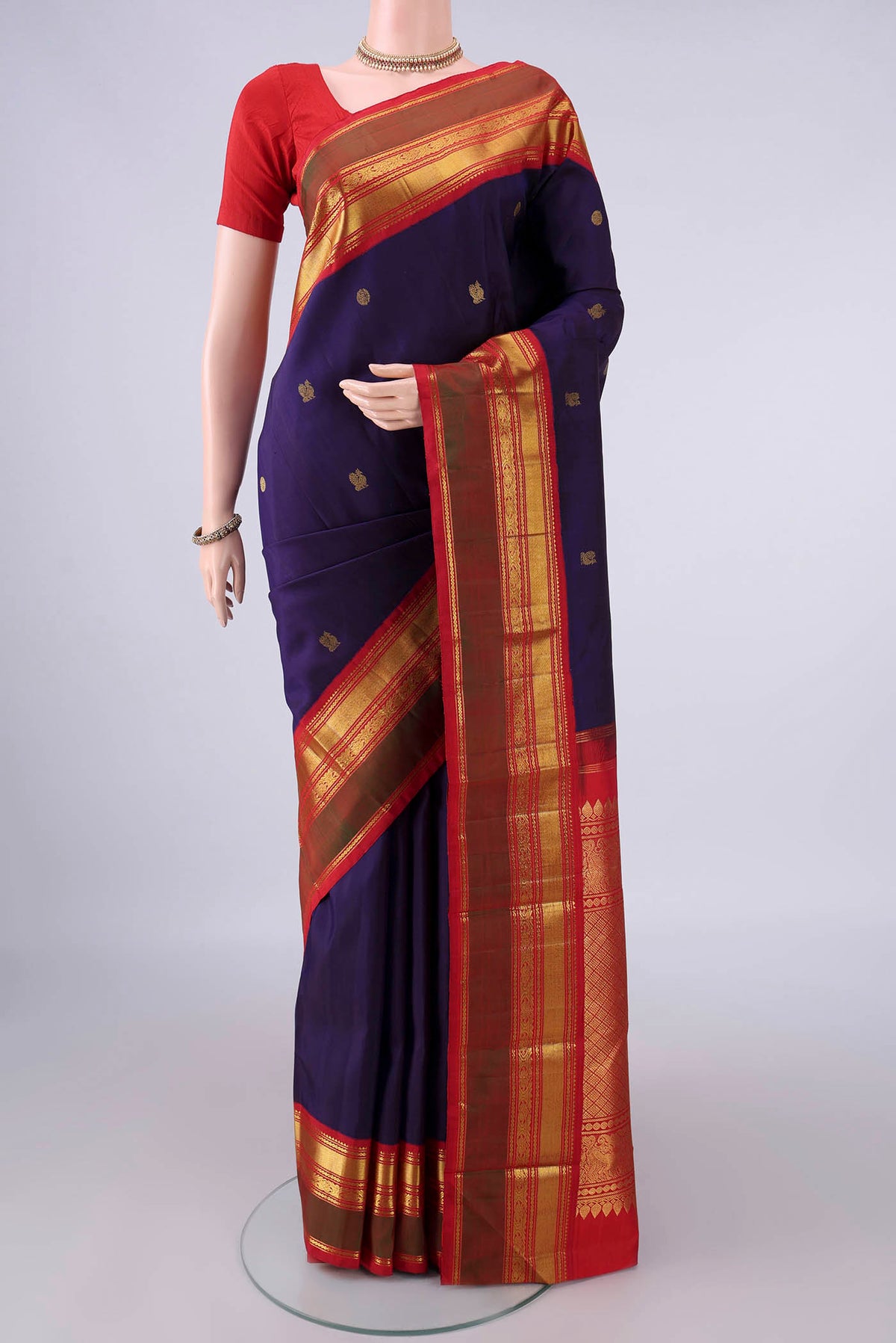 Pure Silk Navy Blue Kanjivaram Saree with Zari Butta on the body and Zari Border.  displayed on a mannequin