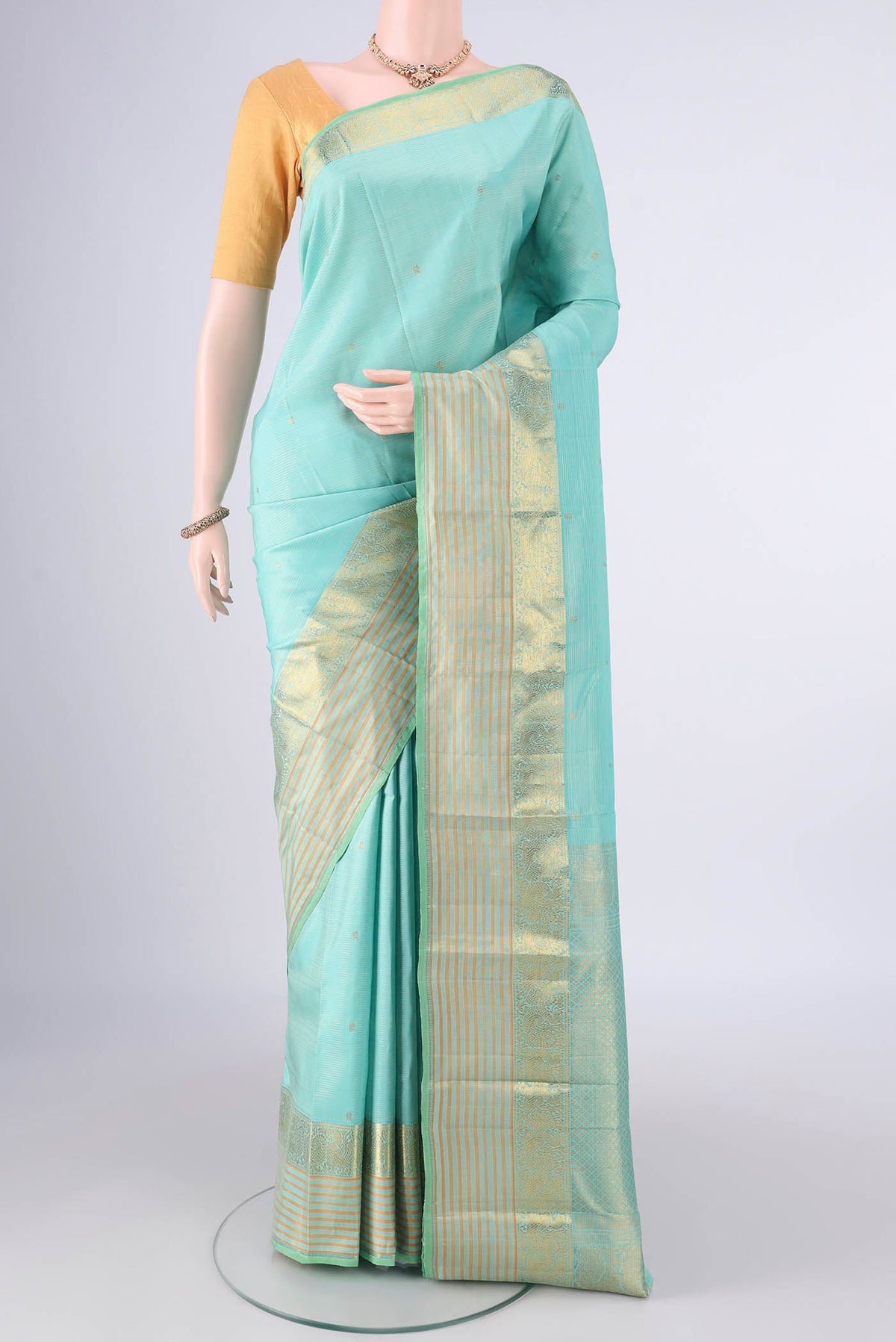 Pure Silk Sea Green Kanjivaram Saree with Zari Butta on the body and Zari Border.  displayed on a mannequin