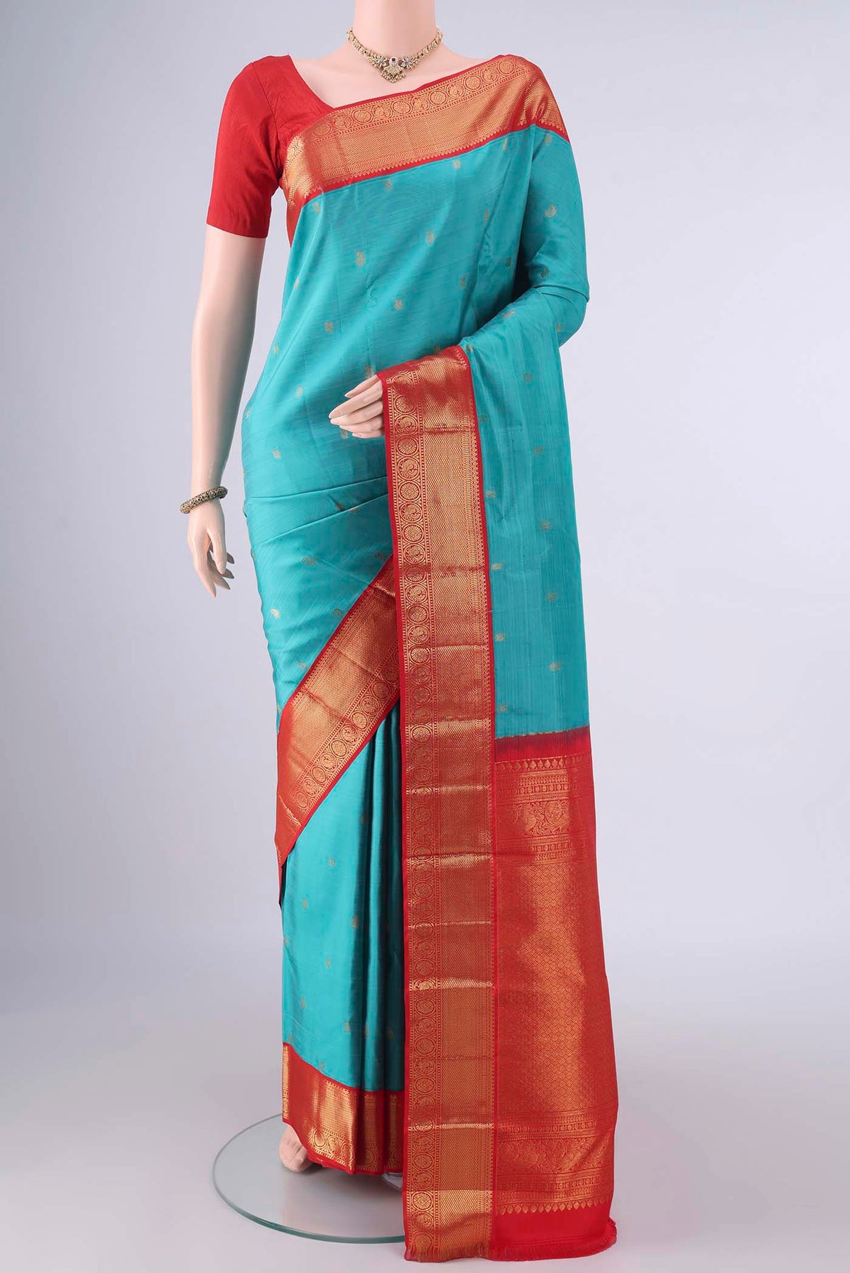 Pure Silk Sea Green Kanjivaram Saree with Zari Butta on the body and Zari Border.  displayed on a mannequin