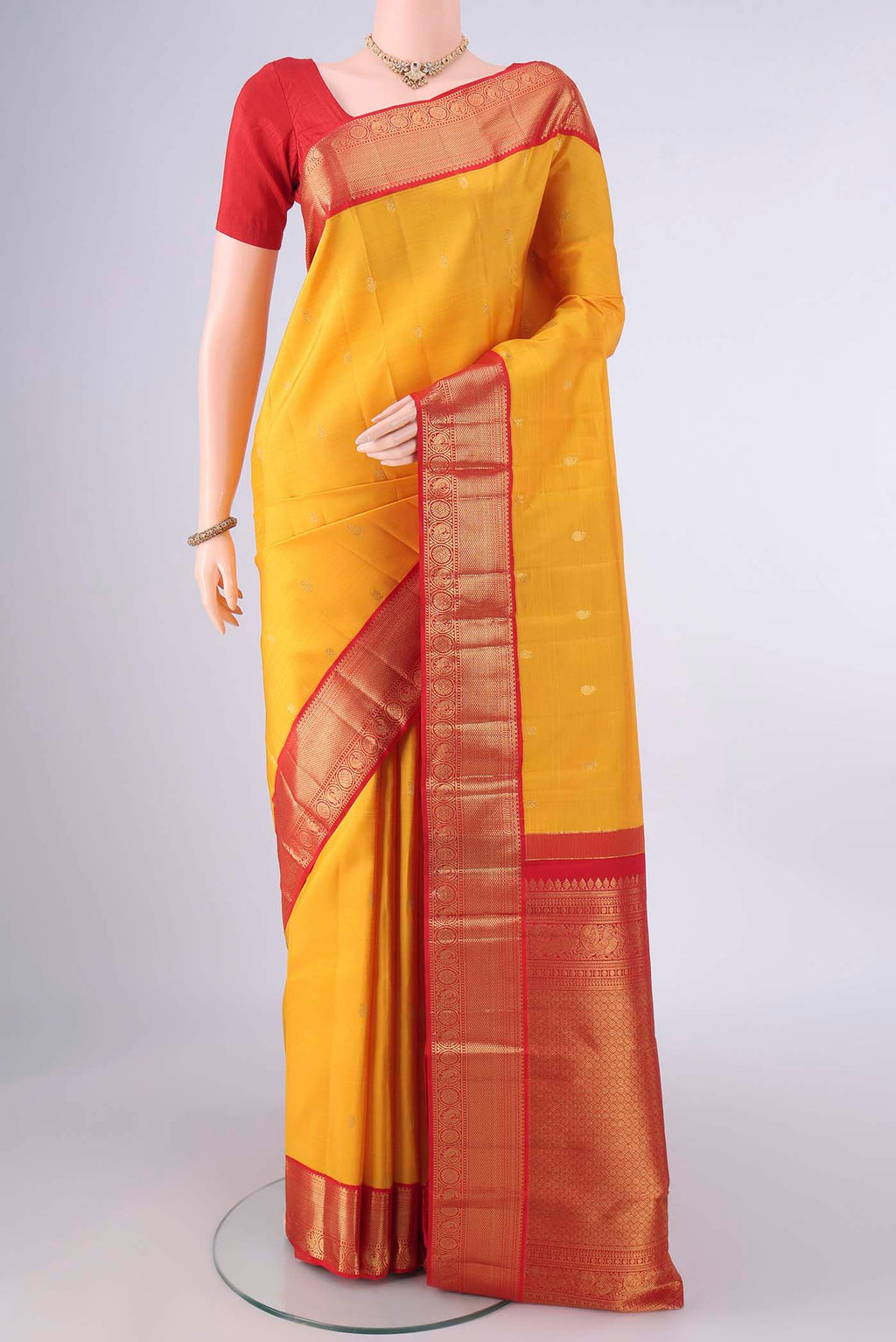 Pure Silk Yellow Kanjivaram Saree with Zari Butta on the body and Zari Border.  displayed on a mannequin