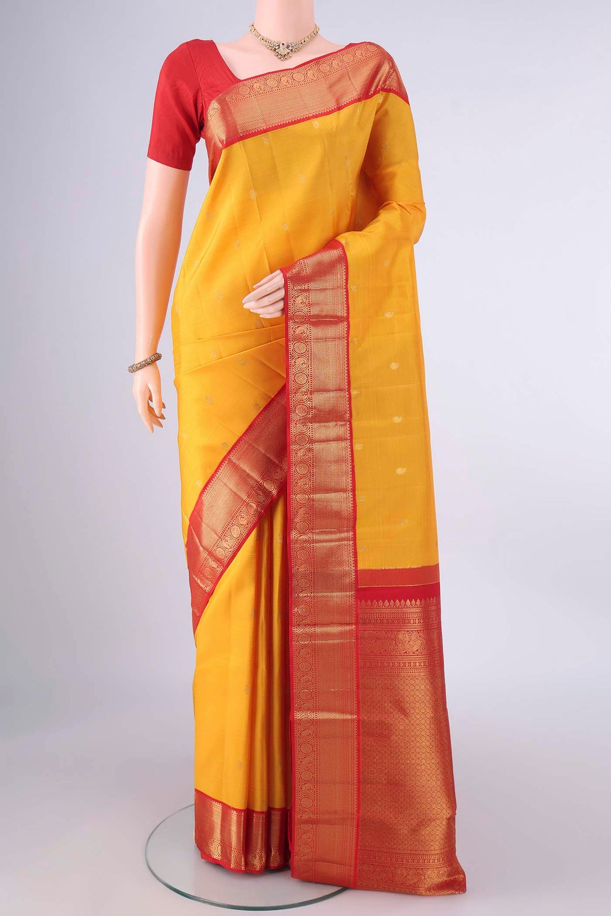 Pure Silk Yellow Kanjivaram Saree with Zari Butta on the body and Zari Border.  displayed on a mannequin