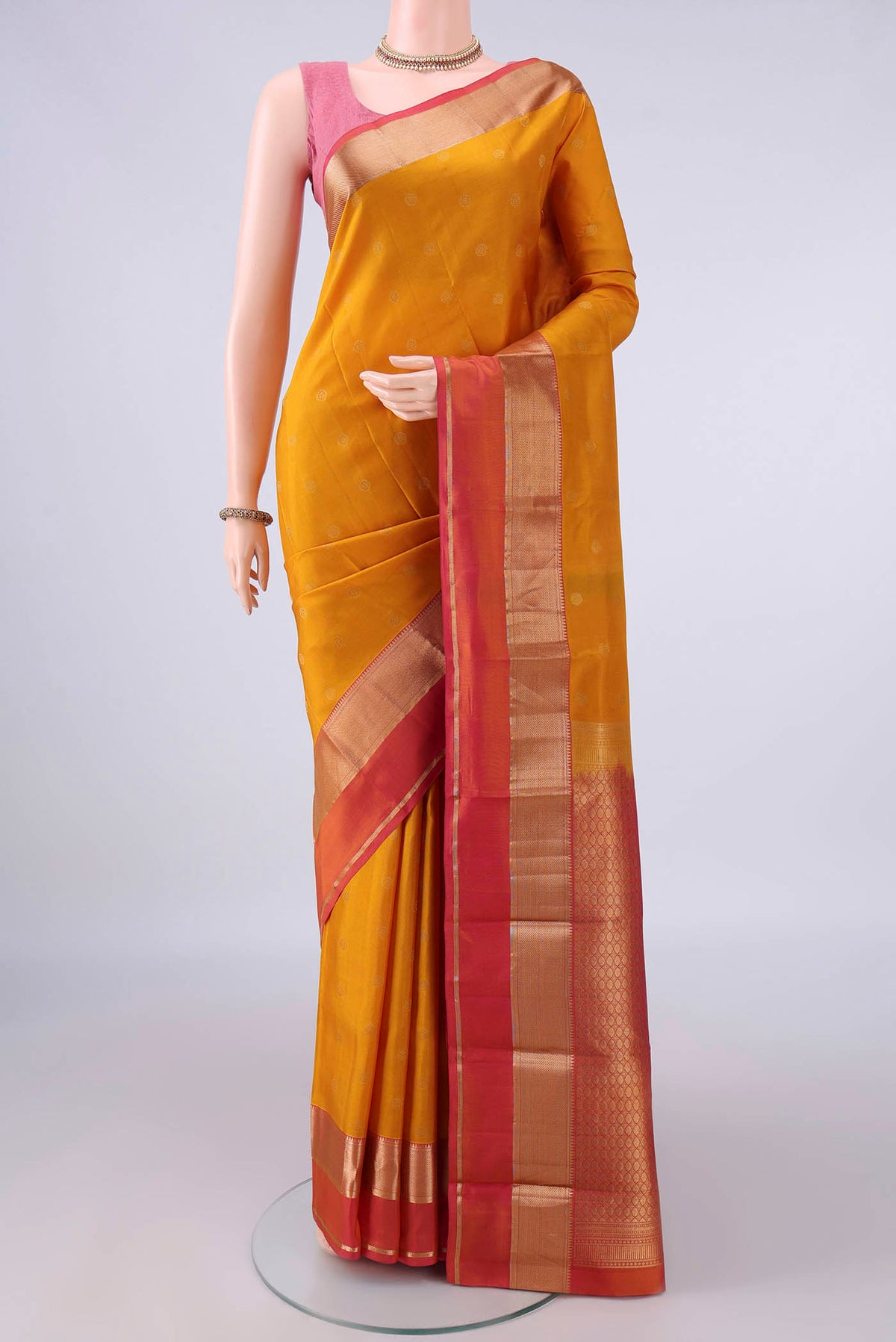 Pure Silk Mustard Kanchipuram Saree with Zari Butta on the body and Zari Border.  displayed on a mannequin