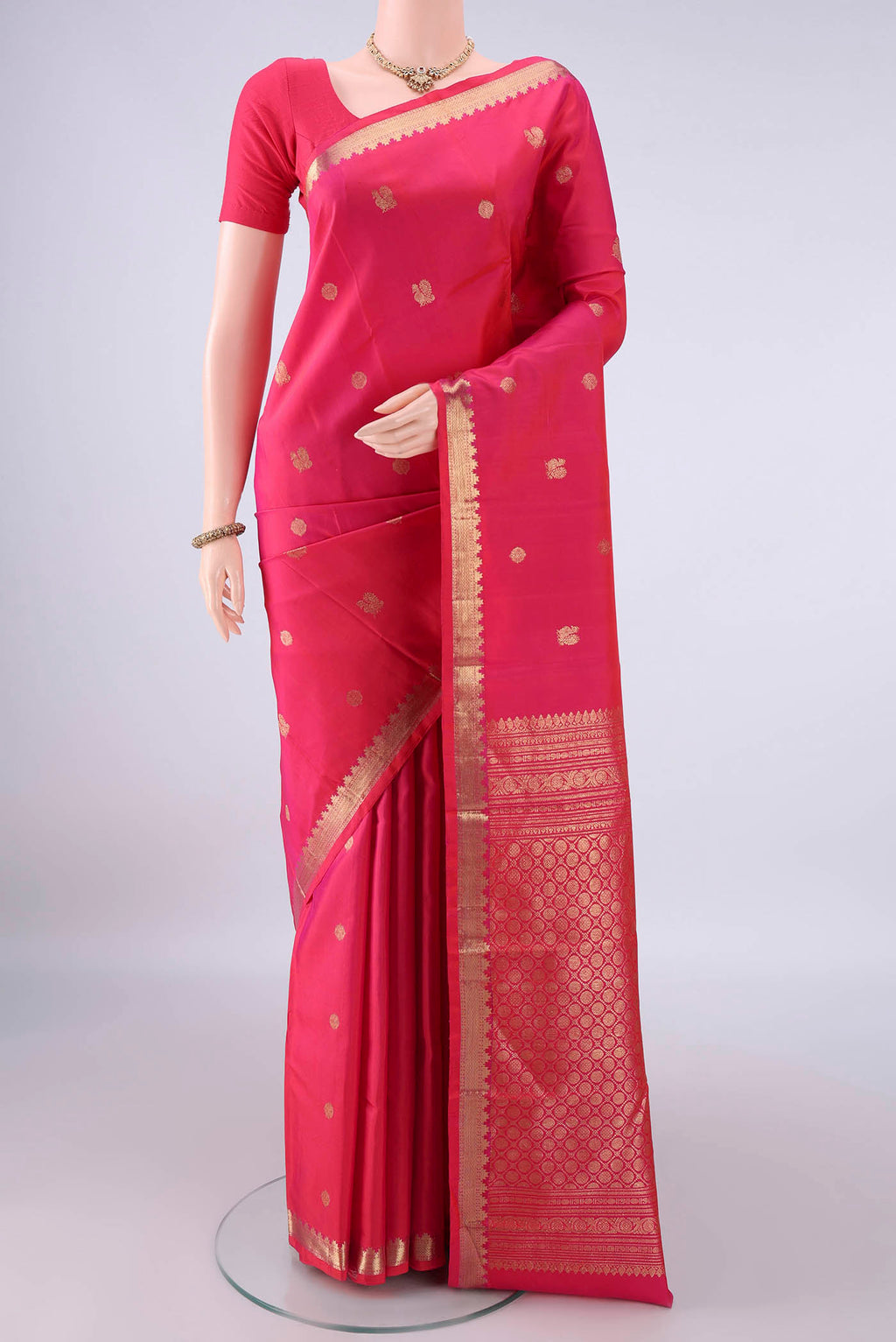 Pure Silk Dark Pink Kanchipuram Saree with Zari Butta on the body and Zari Border.  displayed on a mannequin