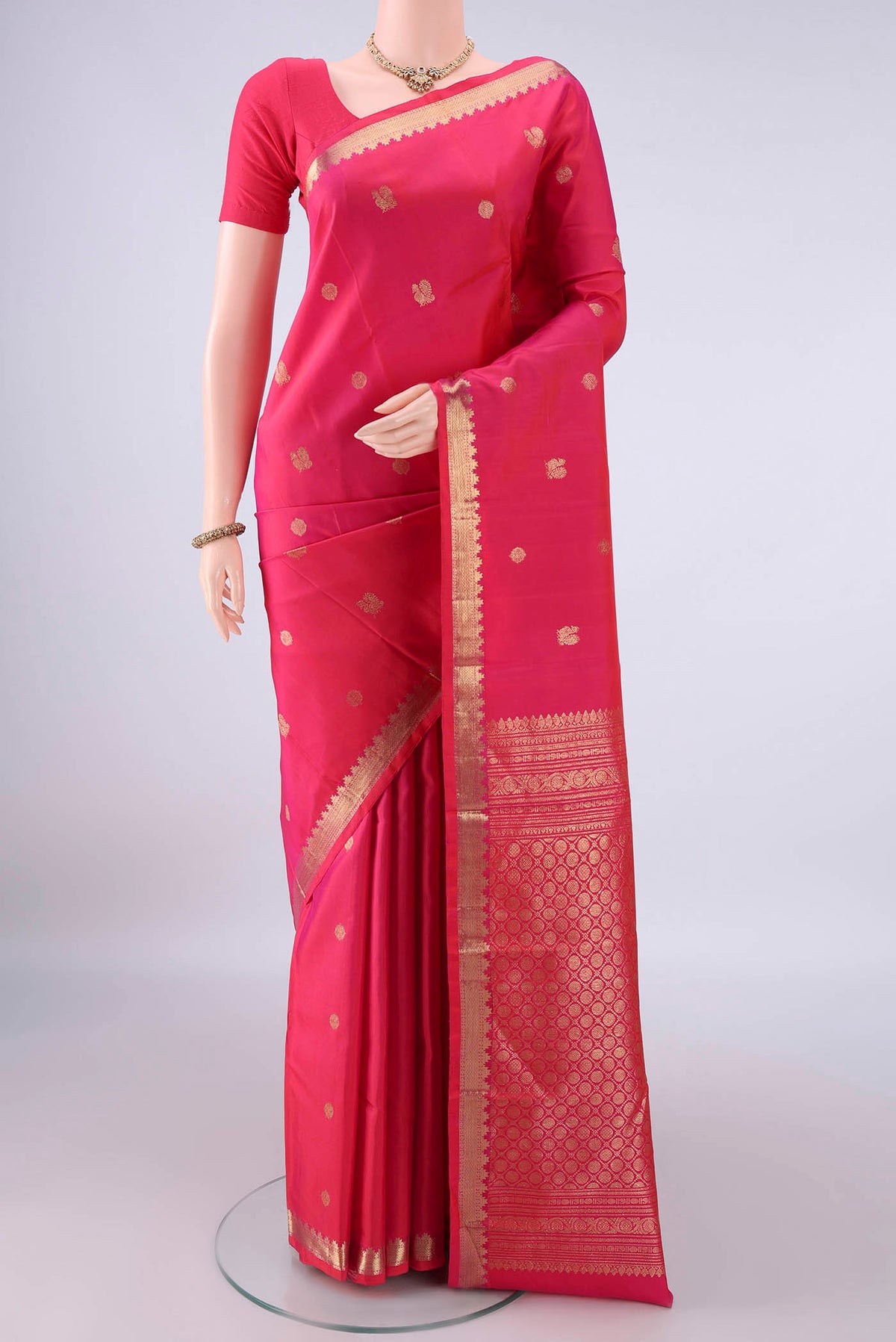 Pure Silk Dark Pink Kanchipuram Saree with Zari Butta on the body and Zari Border.  displayed on a mannequin