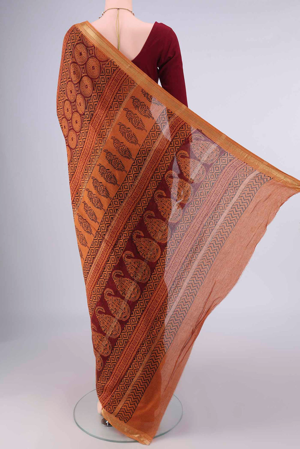 Flat view of Maroon Maheshwari Cotton Saree with Printed design on the body and Zari Border. 