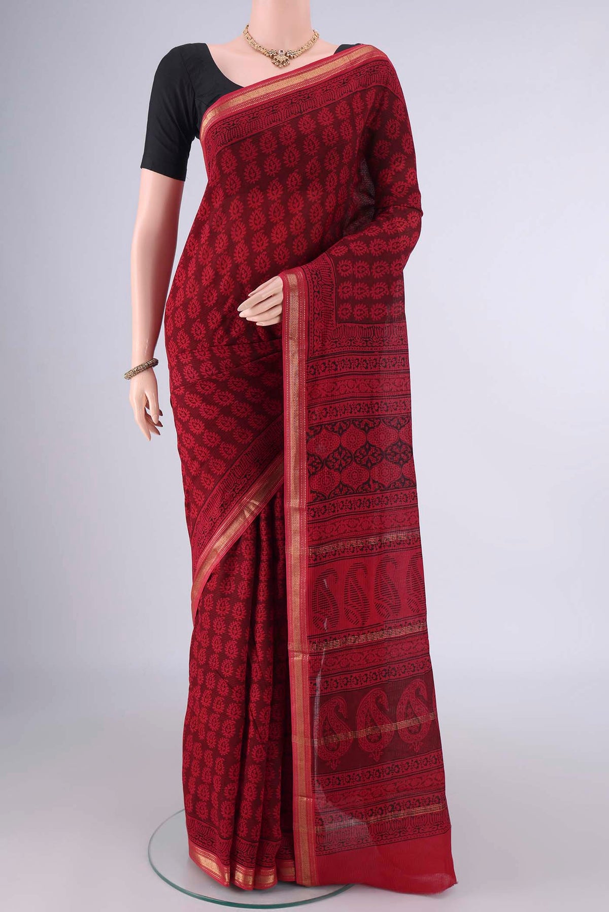 Red Maheshwari Cotton Saree with Printed design on the body and Zari Border.  displayed on a mannequin
