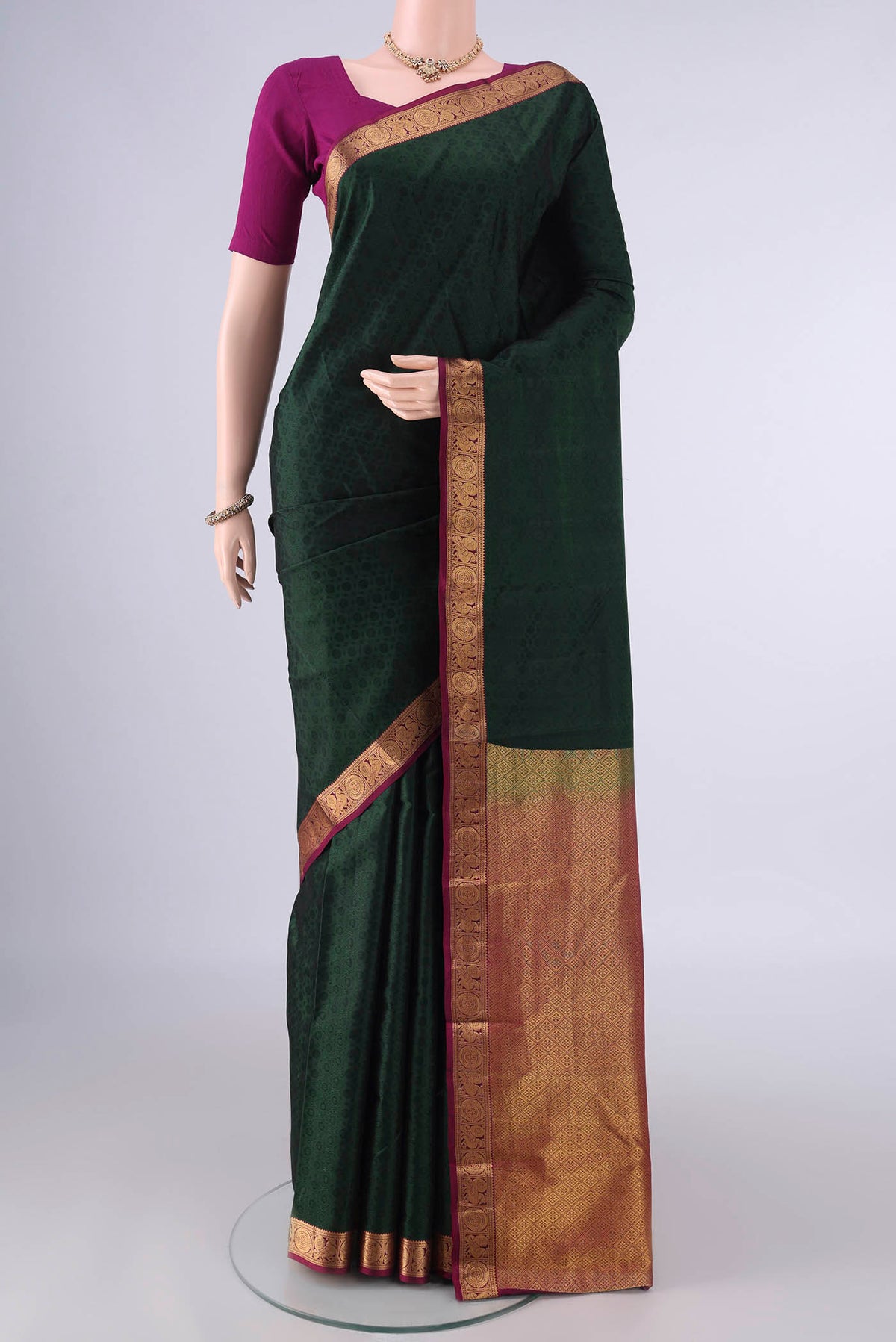 Pure Silk Bottle Green Kanjivaram Saree with Jacquard design on the body and Zari Border.  displayed on a mannequin