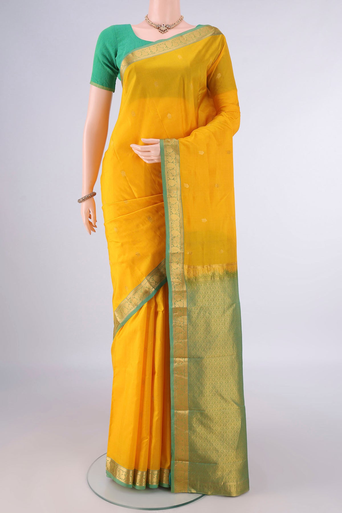 Pure Silk Yellow Kanjivaram Saree with Zari Butta on the body and Zari Border.  displayed on a mannequin
