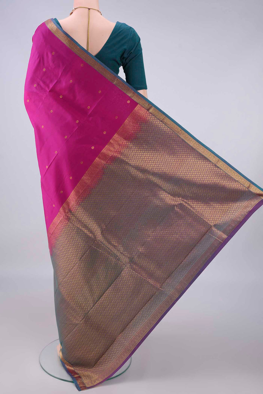 Flat view of Pure Silk Rani Pink Kanjivaram Saree with Zari Butta on the body and Ganga Jamuna Border. 
