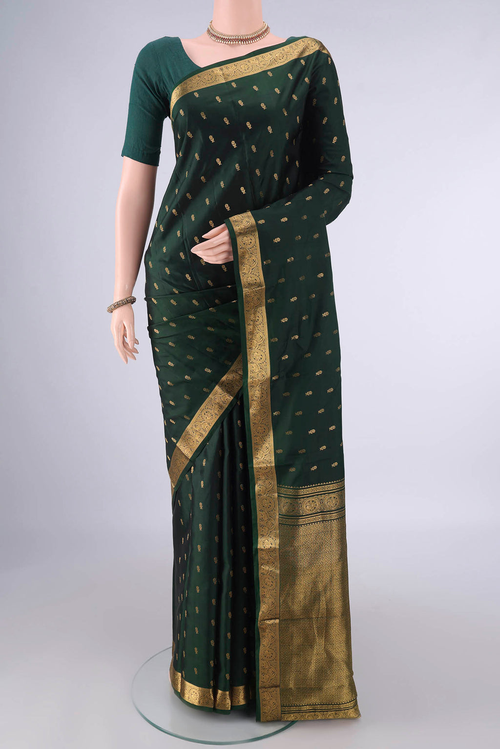 Pure Silk Bottle Green Kanchipuram Saree with Zari Butta on the body and Zari Border.  displayed on a mannequin