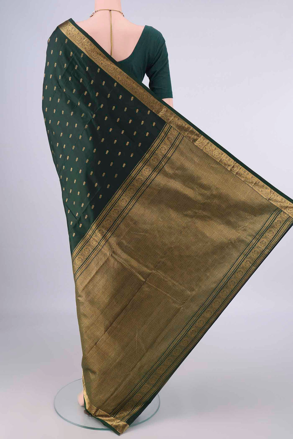 Flat view of Pure Silk Bottle Green Kanchipuram Saree with Zari Butta on the body and Zari Border. 