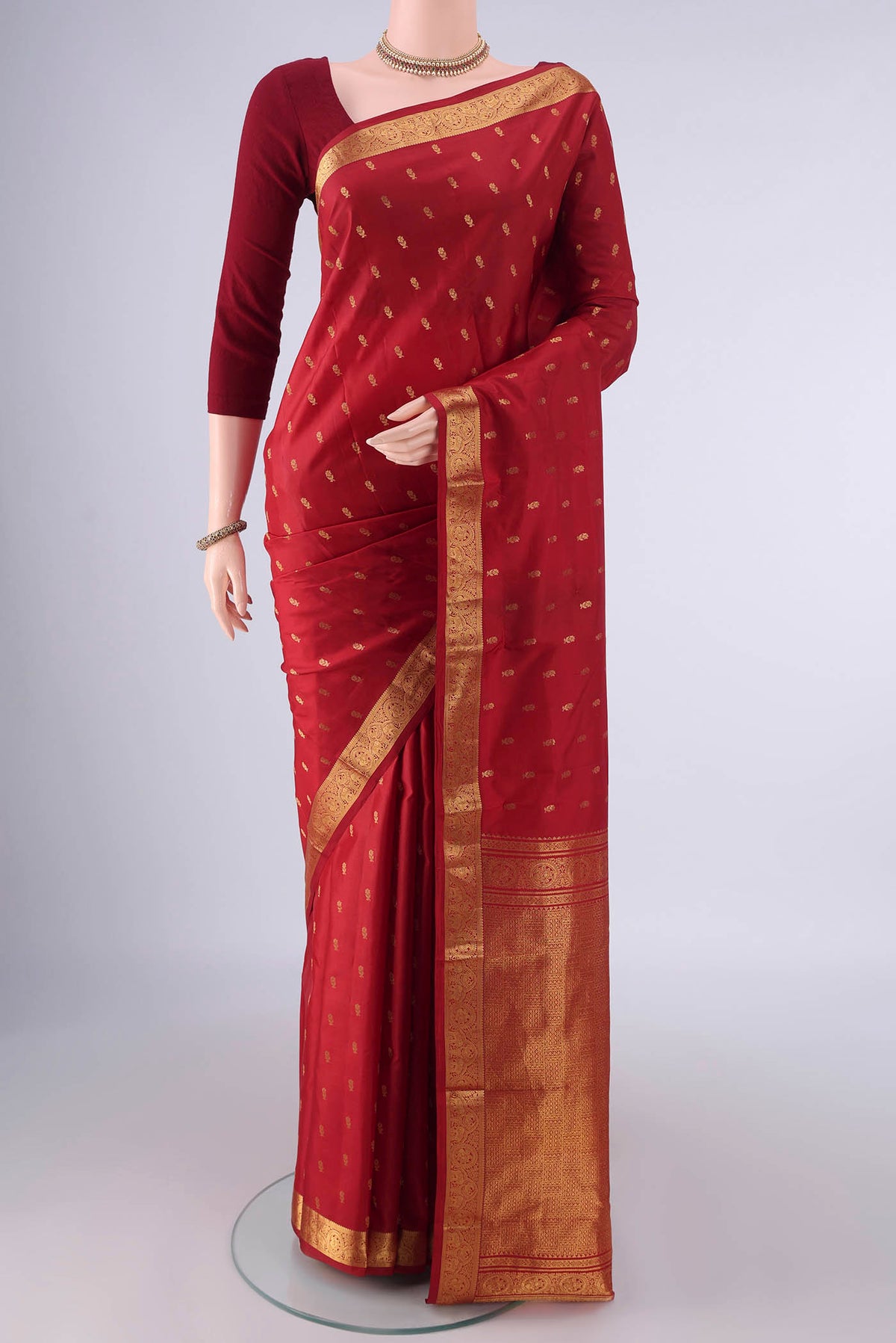 Pure Silk Red Kanchipuram Saree with Zari Butta on the body and Zari Border.  displayed on a mannequin