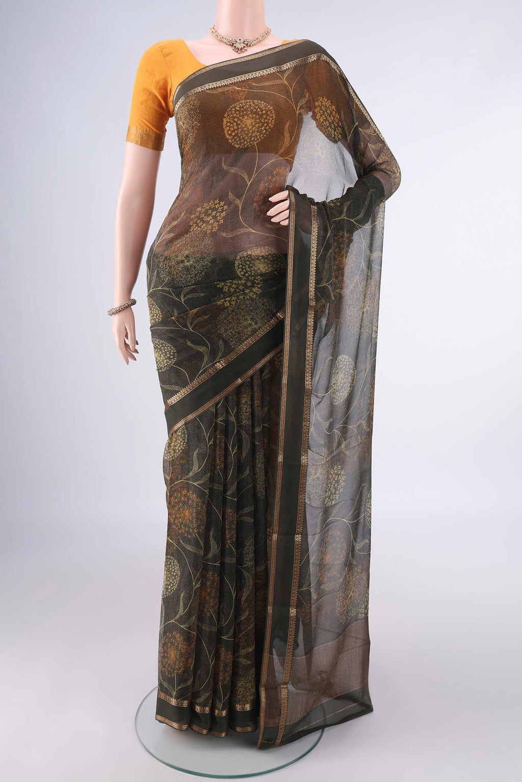 Olive Green Mysore Chiffon Saree with Printed design on the body and Zari Border.  displayed on a mannequin