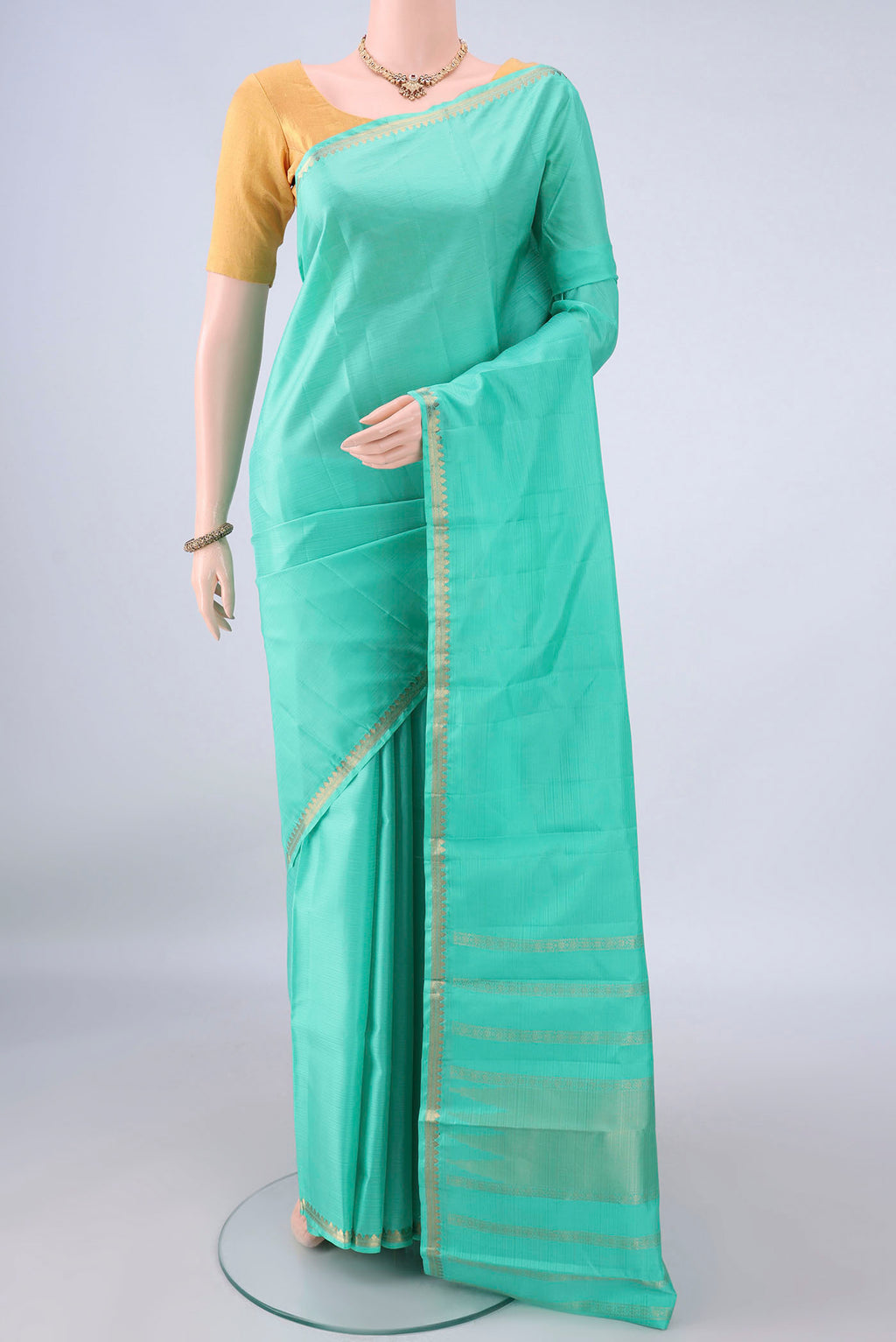 Pure Silk Sea Green Kanjivaram Saree with Plain Body and Zari Border.  displayed on a mannequin