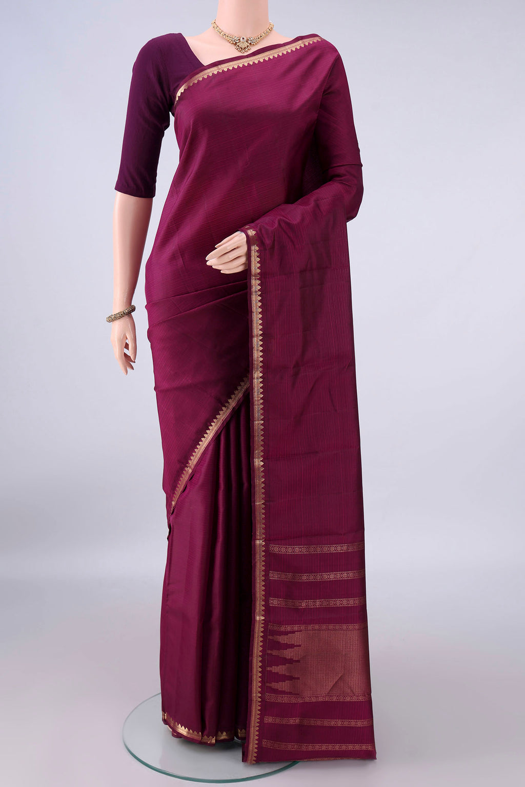 Pure Silk Maroon Kanjivaram Saree with Plain Body and Zari Border.  displayed on a mannequin