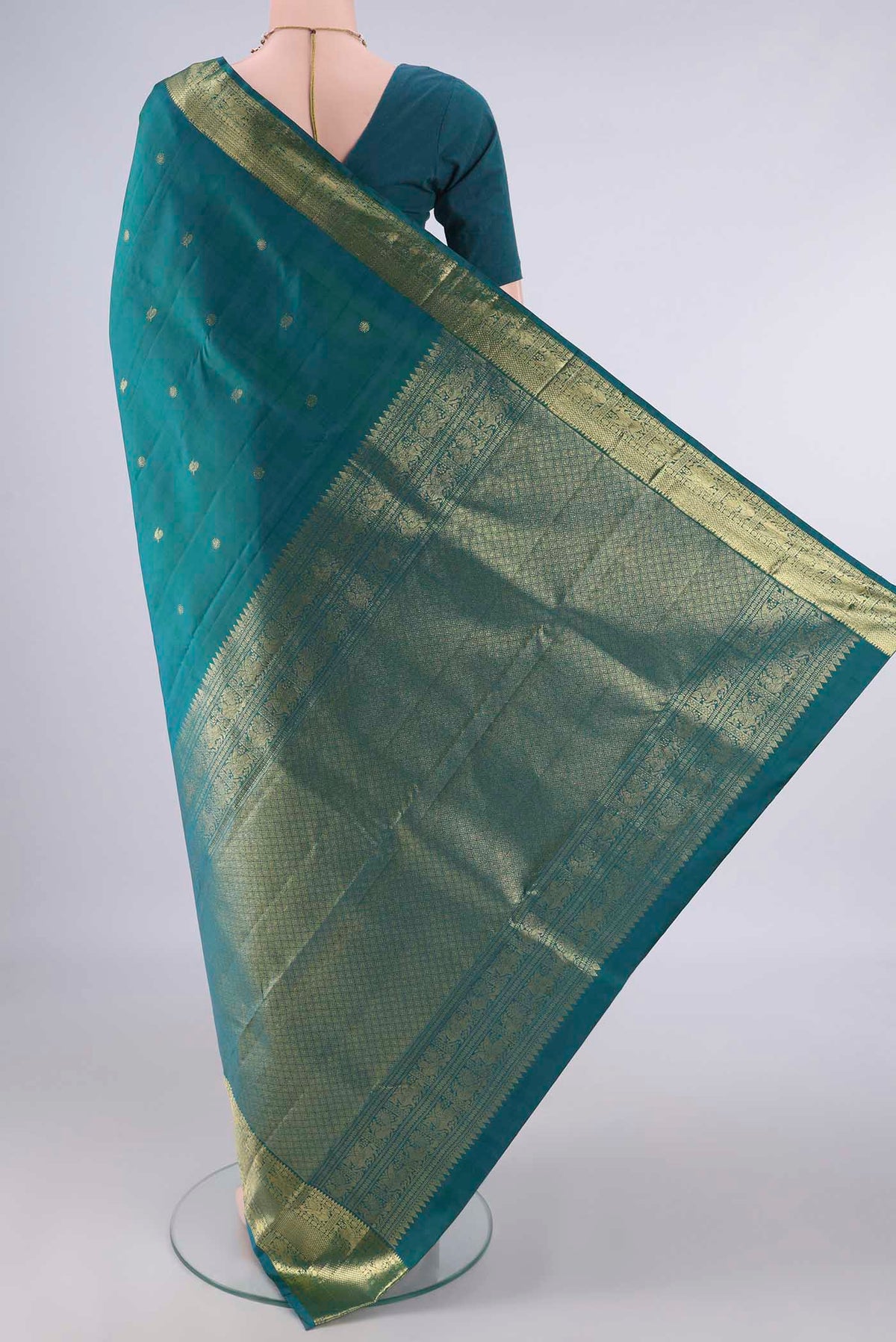 Flat view of Pure Silk Teal Kanchipuram Saree with Zari Butta on the body and Zari Border. 