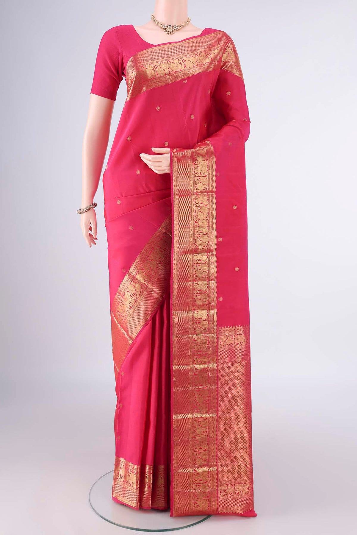 Pure Silk Rani Pink Kanchipuram Saree with Zari Butta on the body and Zari Border.  displayed on a mannequin
