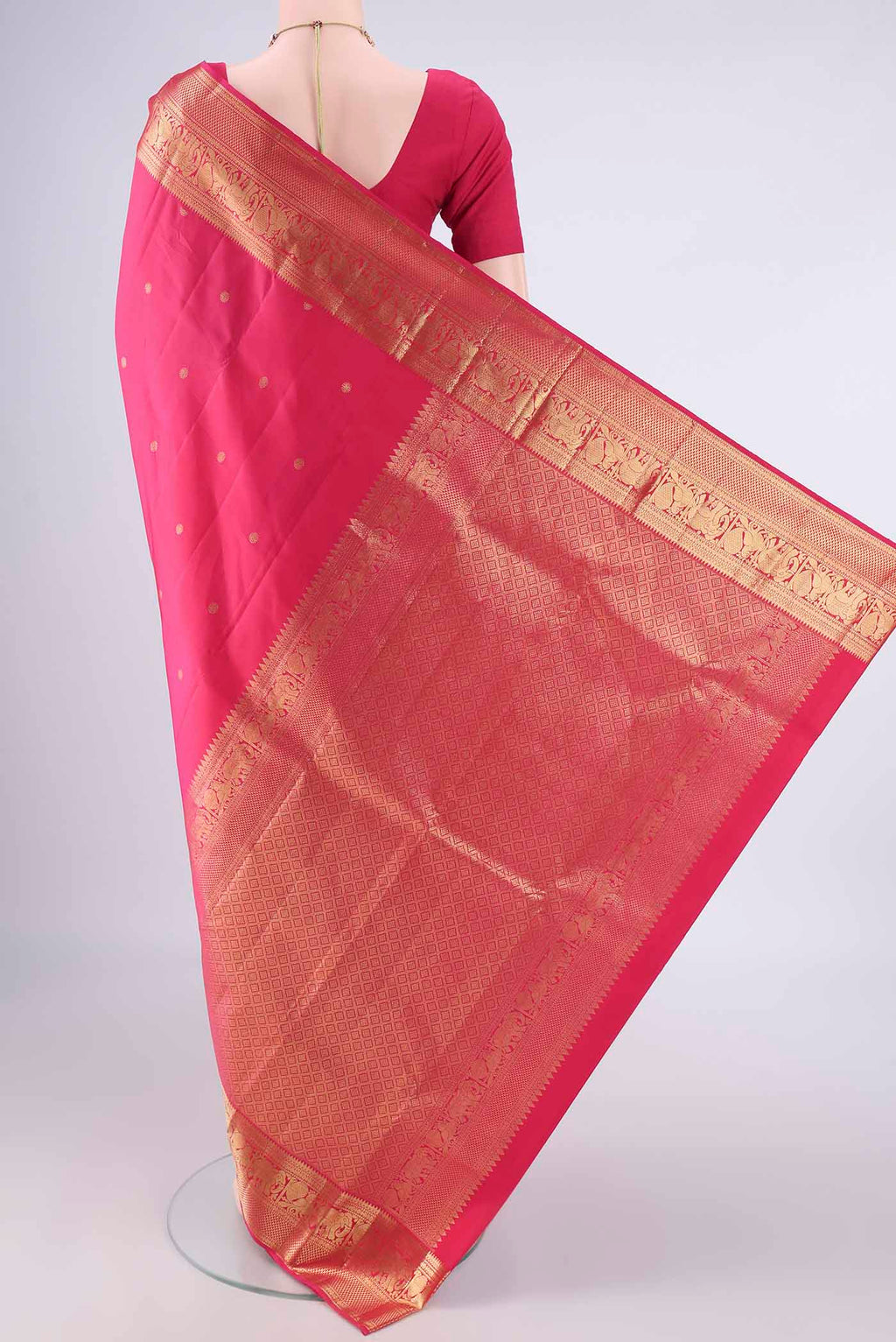 Flat view of Pure Silk Rani Pink Kanchipuram Saree with Zari Butta on the body and Zari Border. 