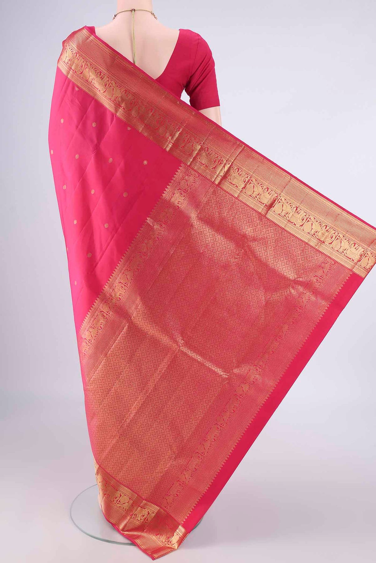Flat view of Pure Silk Rani Pink Kanchipuram Saree with Zari Butta on the body and Zari Border. 