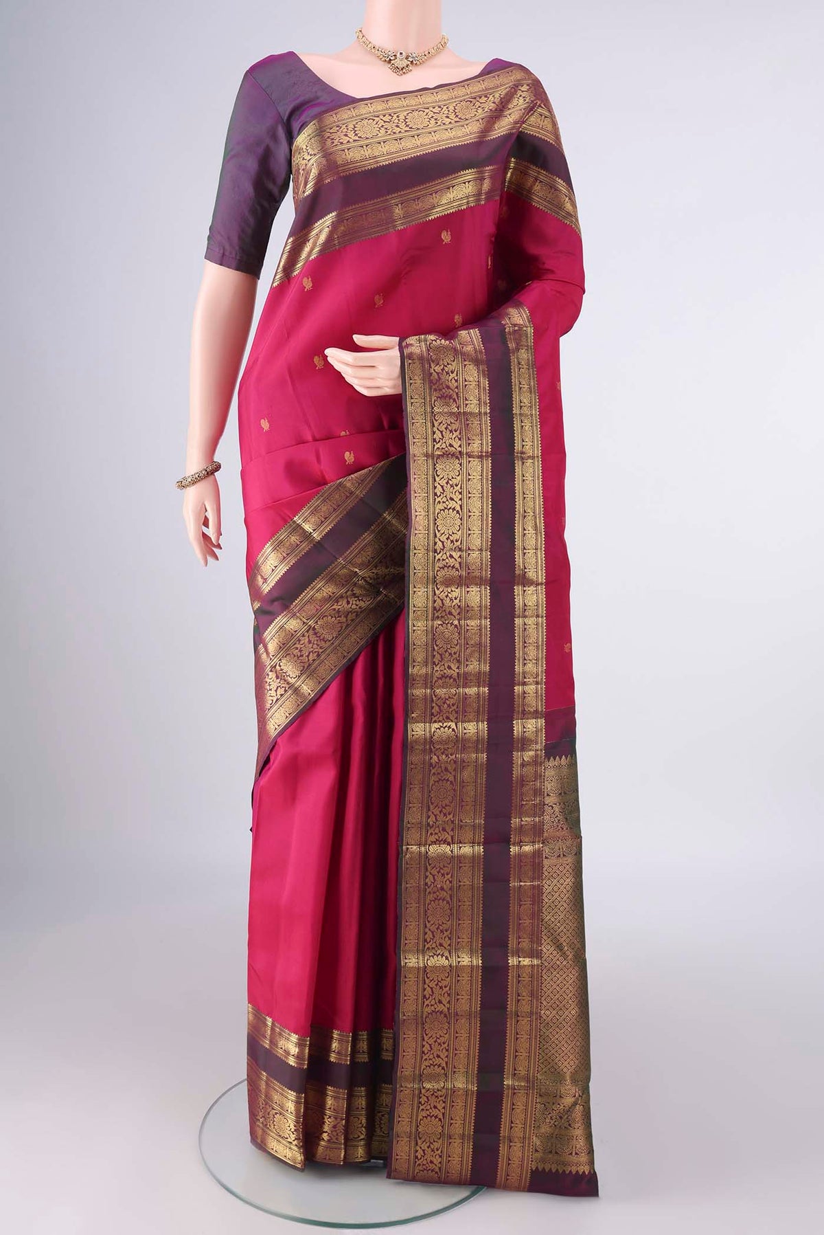 Pure Silk Rani Pink Kanchipuram Saree with Zari Butta on the body and Zari Border.  displayed on a mannequin