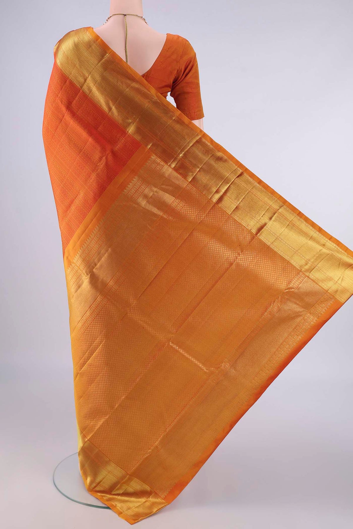 Flat view of Pure Silk Orange Kanjivaram Saree with Jacquard design on the body and Zari Border. 