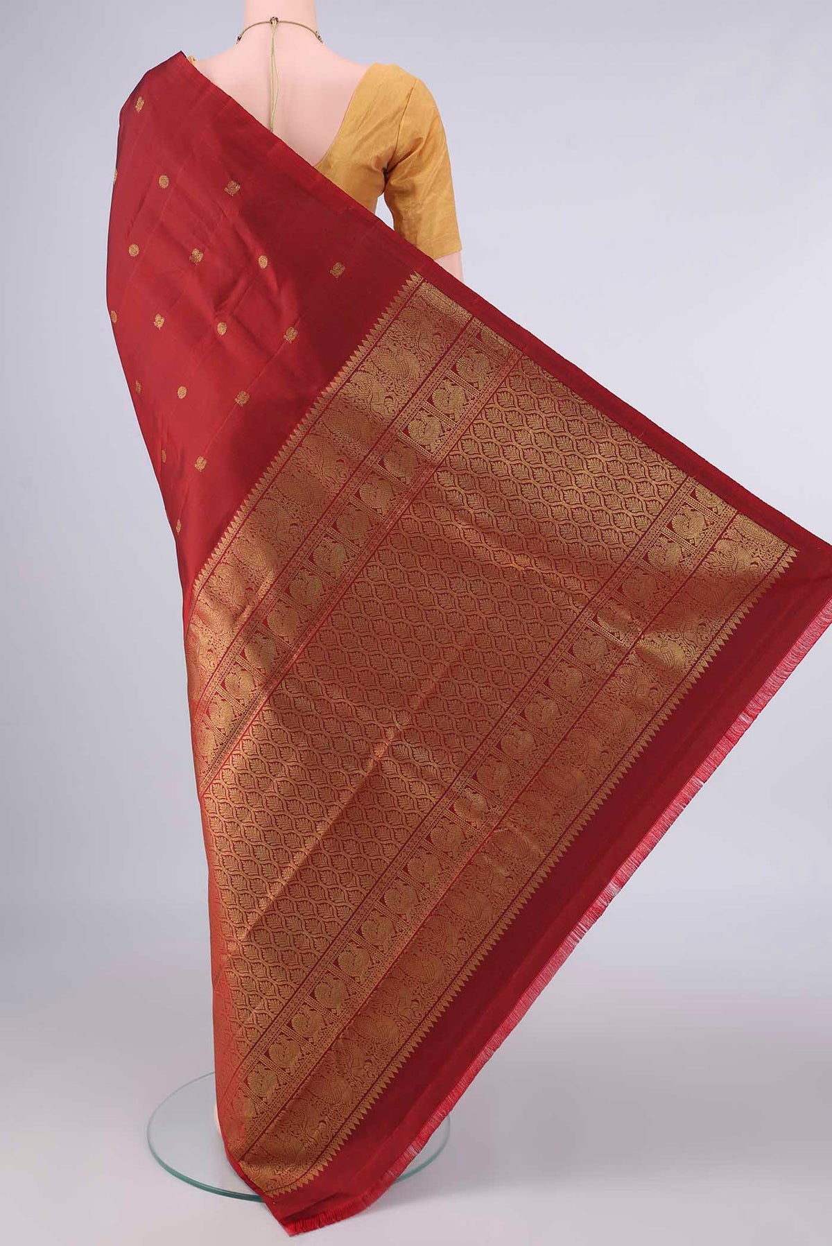 Flat view of Pure Silk Rust Kanchipuram Saree with Zari Butta on the body and Without Border. 