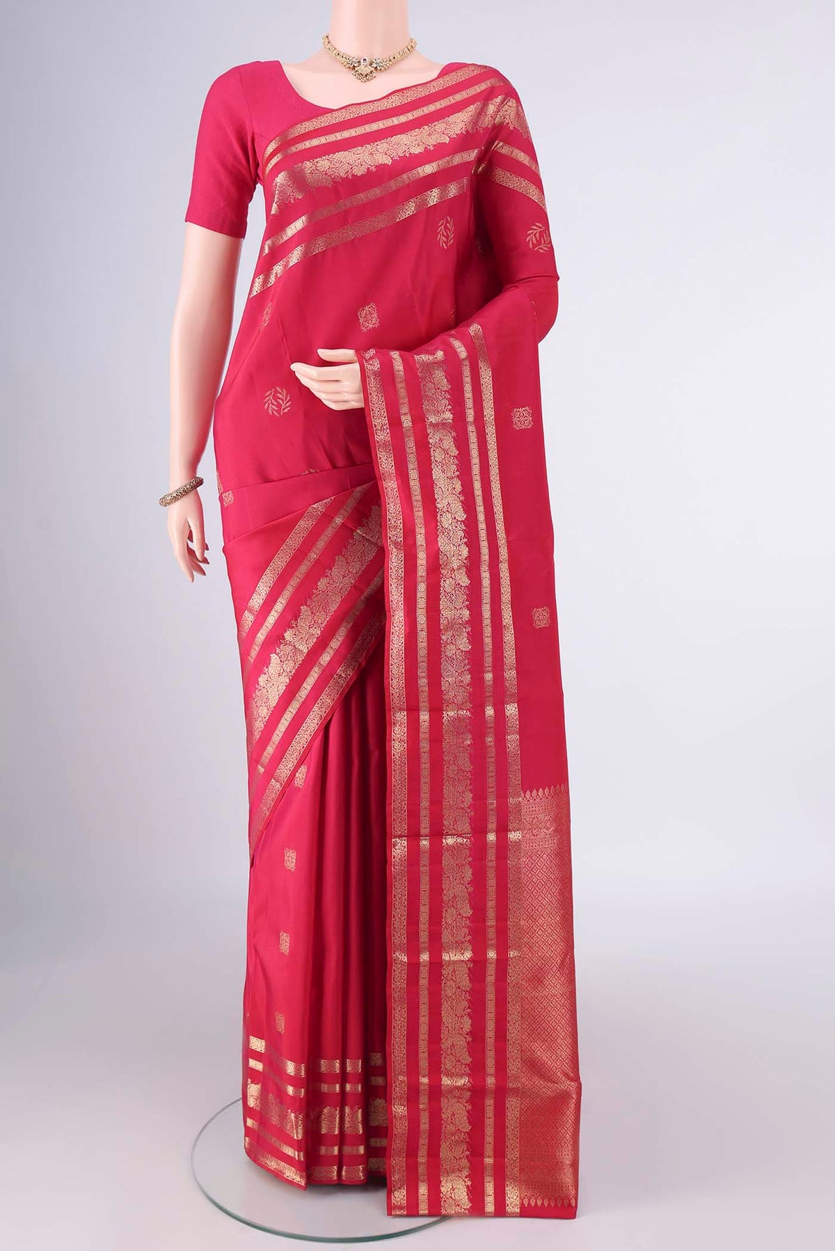 Pure Silk Rani Pink Kanjivaram Saree with Zari Butta on the body and Zari Border.  displayed on a mannequin
