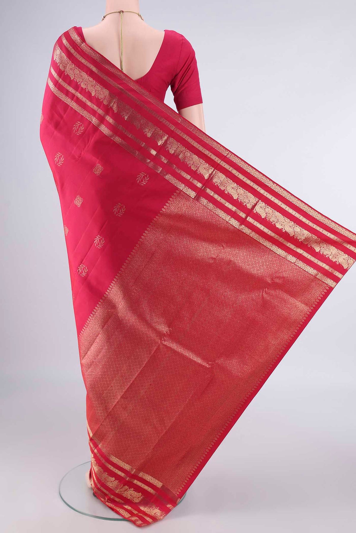Flat view of Pure Silk Rani Pink Kanjivaram Saree with Zari Butta on the body and Zari Border. 