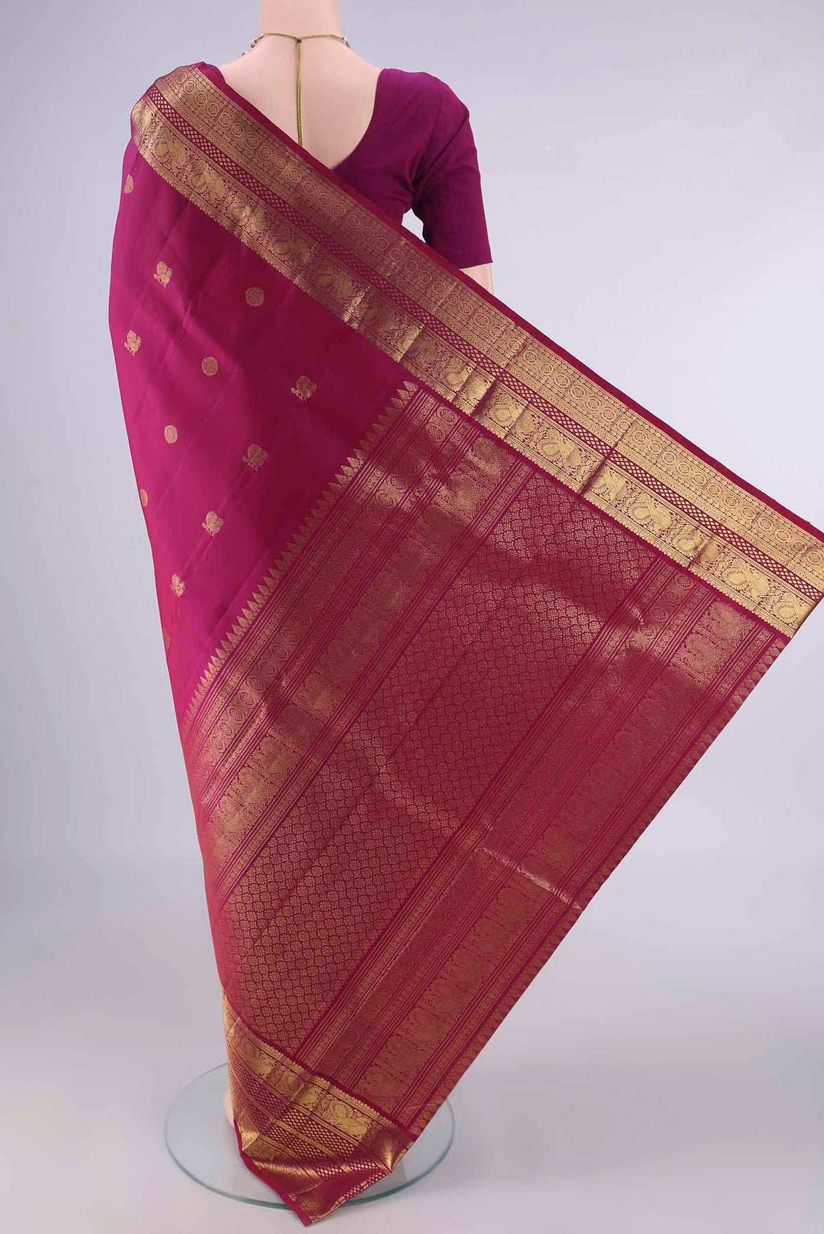 Flat view of Pure Silk Magenta Kanjivaram Saree with Zari Butta on the body and Zari Border. 