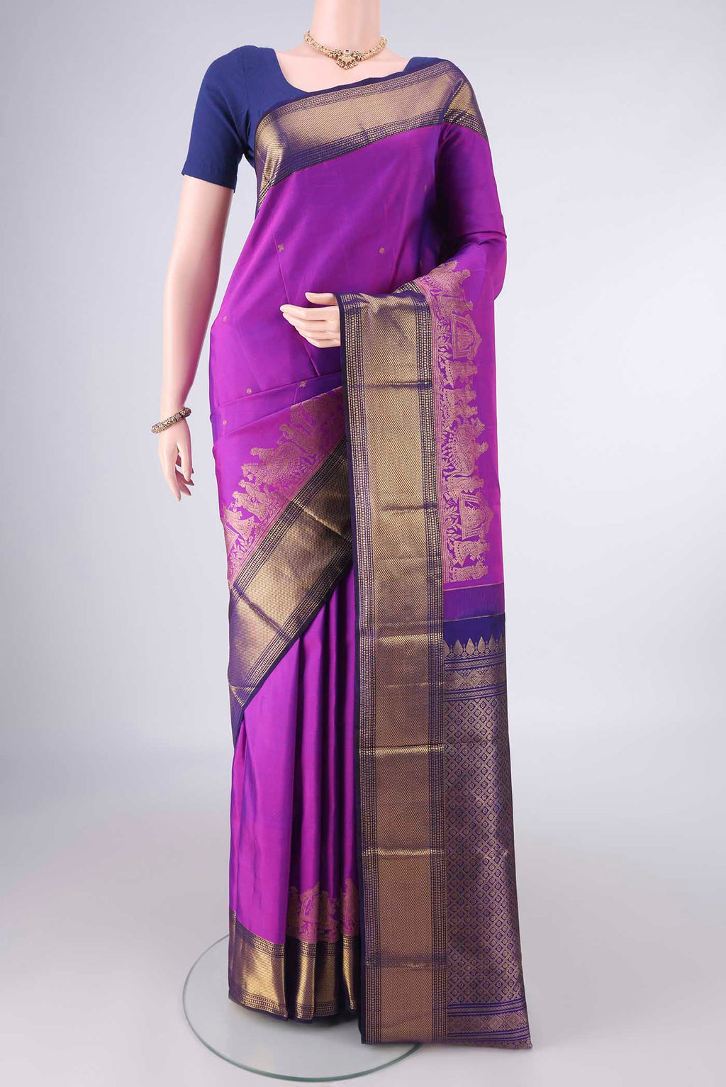 Pure Silk Magenta Kanjivaram Saree with Zari Butta on the body and Zari Border.  displayed on a mannequin